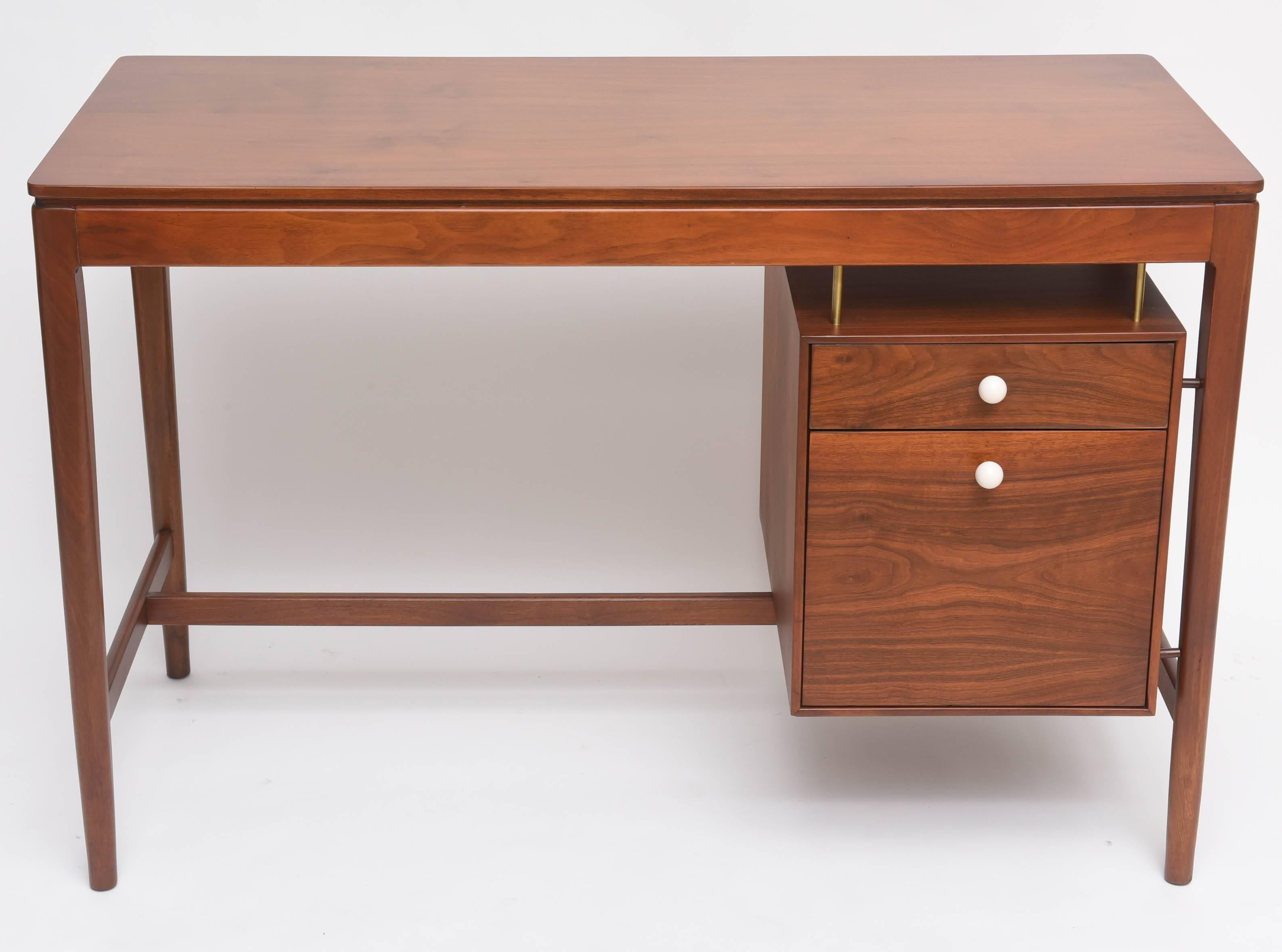 Handsome desk by Kipp Stewart for Drexel. Walnut, with original white ceramic knobs and brass hardware.