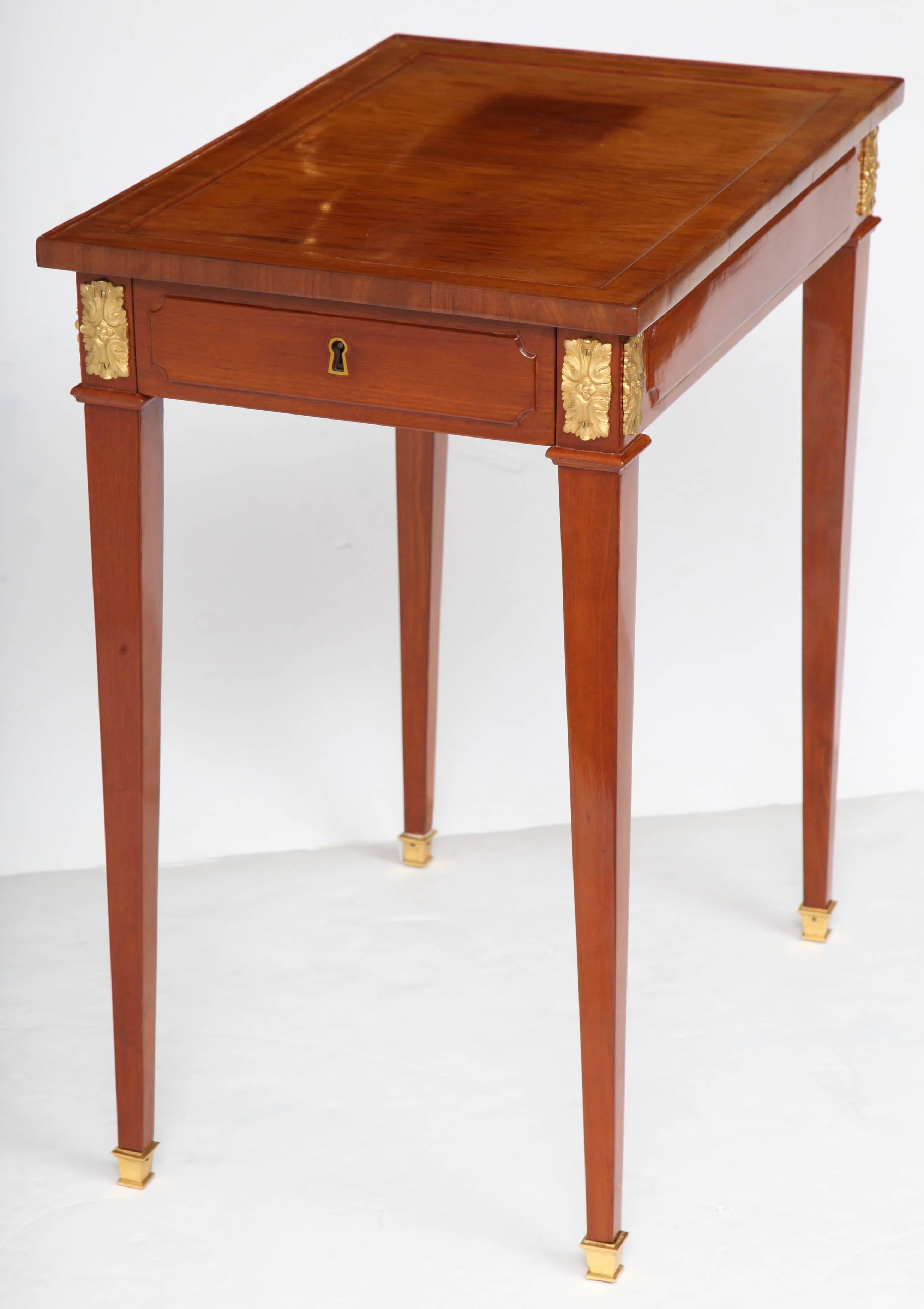 A Louis XVI period ormolu-mounted writing table with a drawer on one end and a writing slide on the other, raised on tapered legs with ormolu sabots.