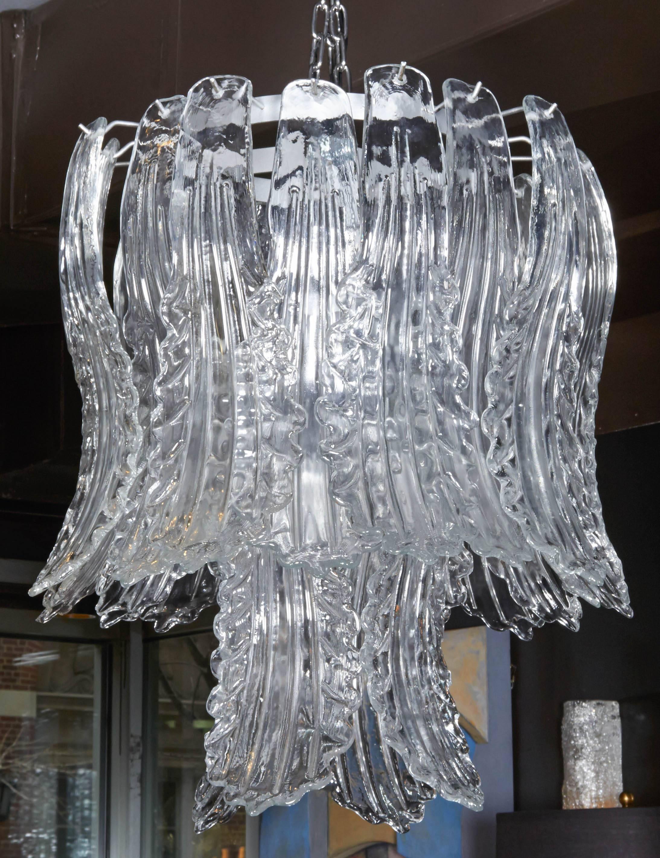 Outstanding chandelier comprised of two tiers of exquisite handblown Murano glass pendants. The large pendants have scrolled forms with stylized acanthus leaf designs. The fixture has a circular frame in silvered steel and consists of mutiple arms