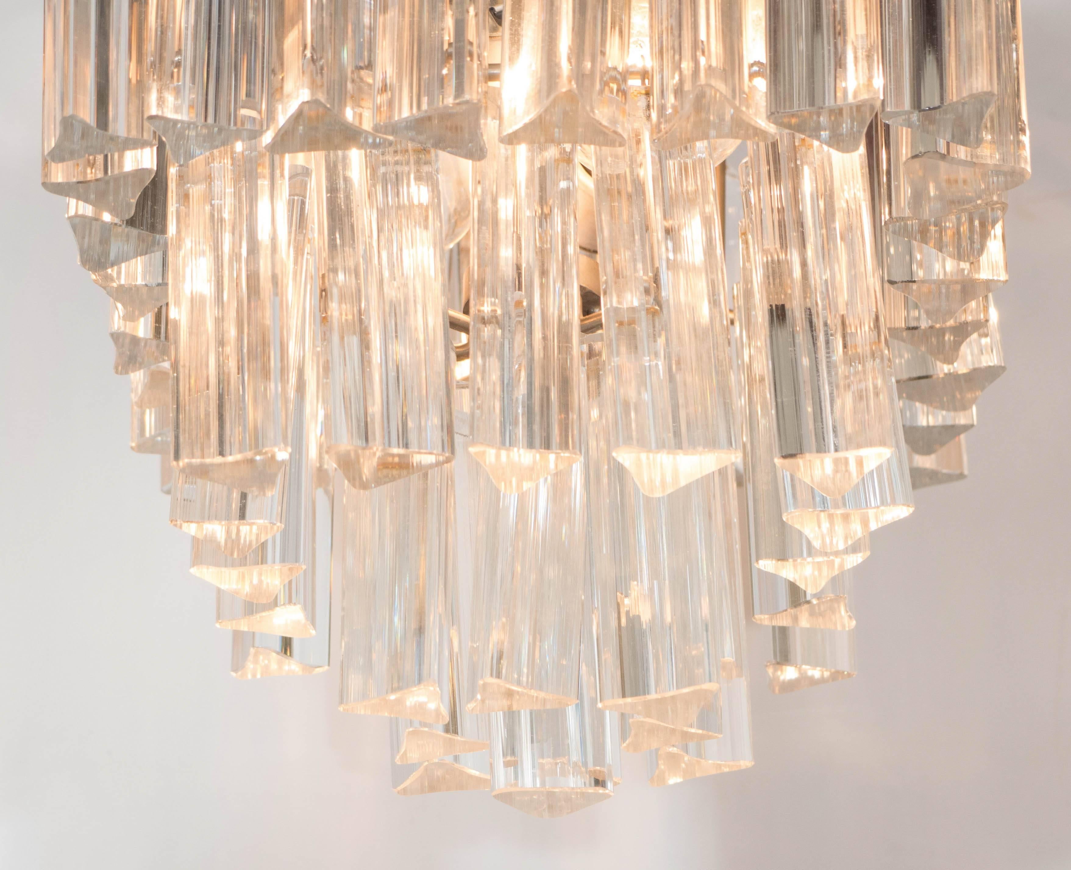 A vintage small-scale chandelier, produced circa 1960s by Venini, with three tiers of 'triedri' Murano glass prisms, suspended from a metal frame. Wiring and sockets to US standard, requires two Edison base bulbs. Very good vintage condition,