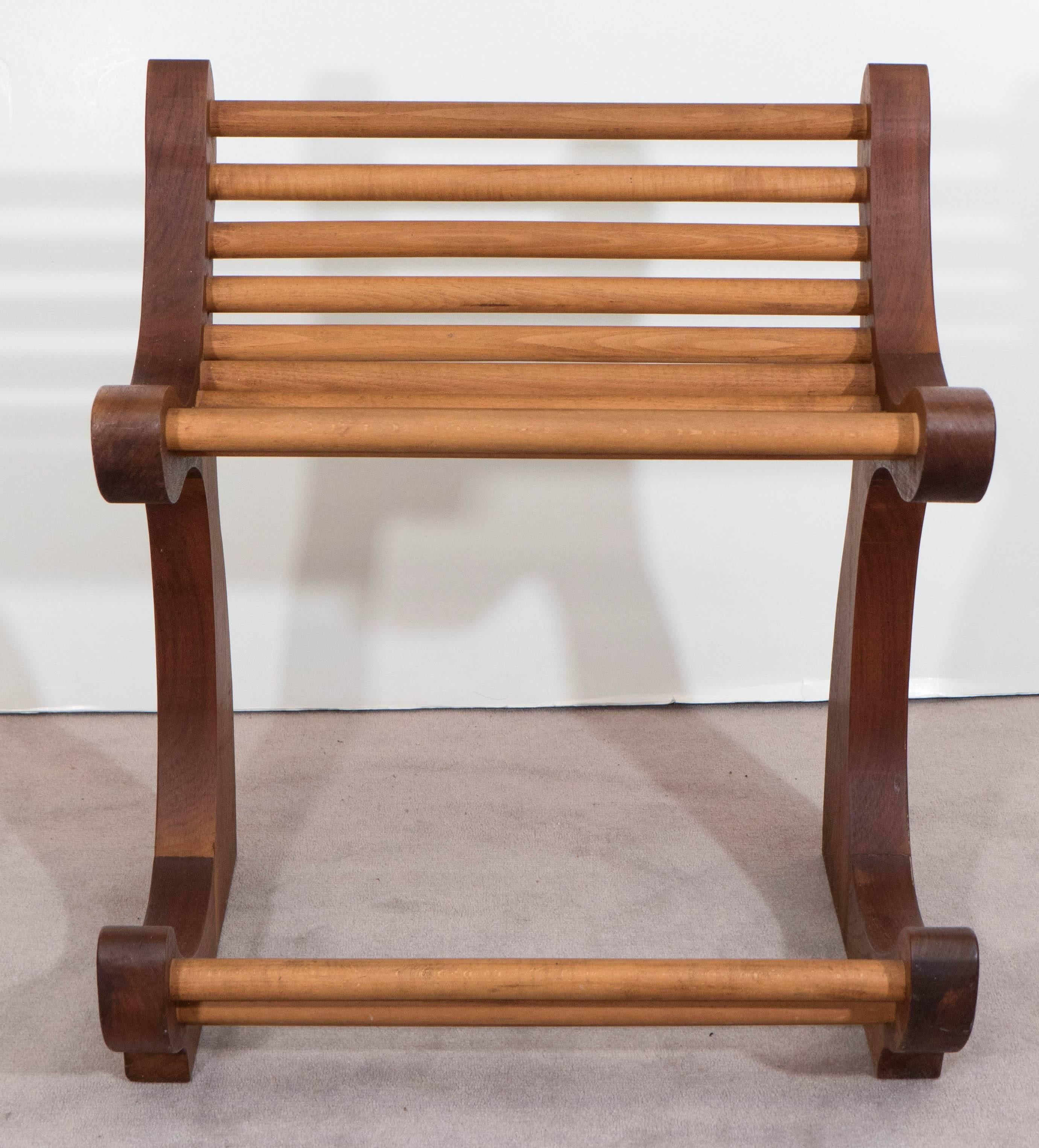 This highly unique 1970s wood chair wonderfully marries modern design with arts and crafts artistry, consisting of dowels to the seat and footrest, inset within a richly toned curved frame. This piece is in overall good condition, with age