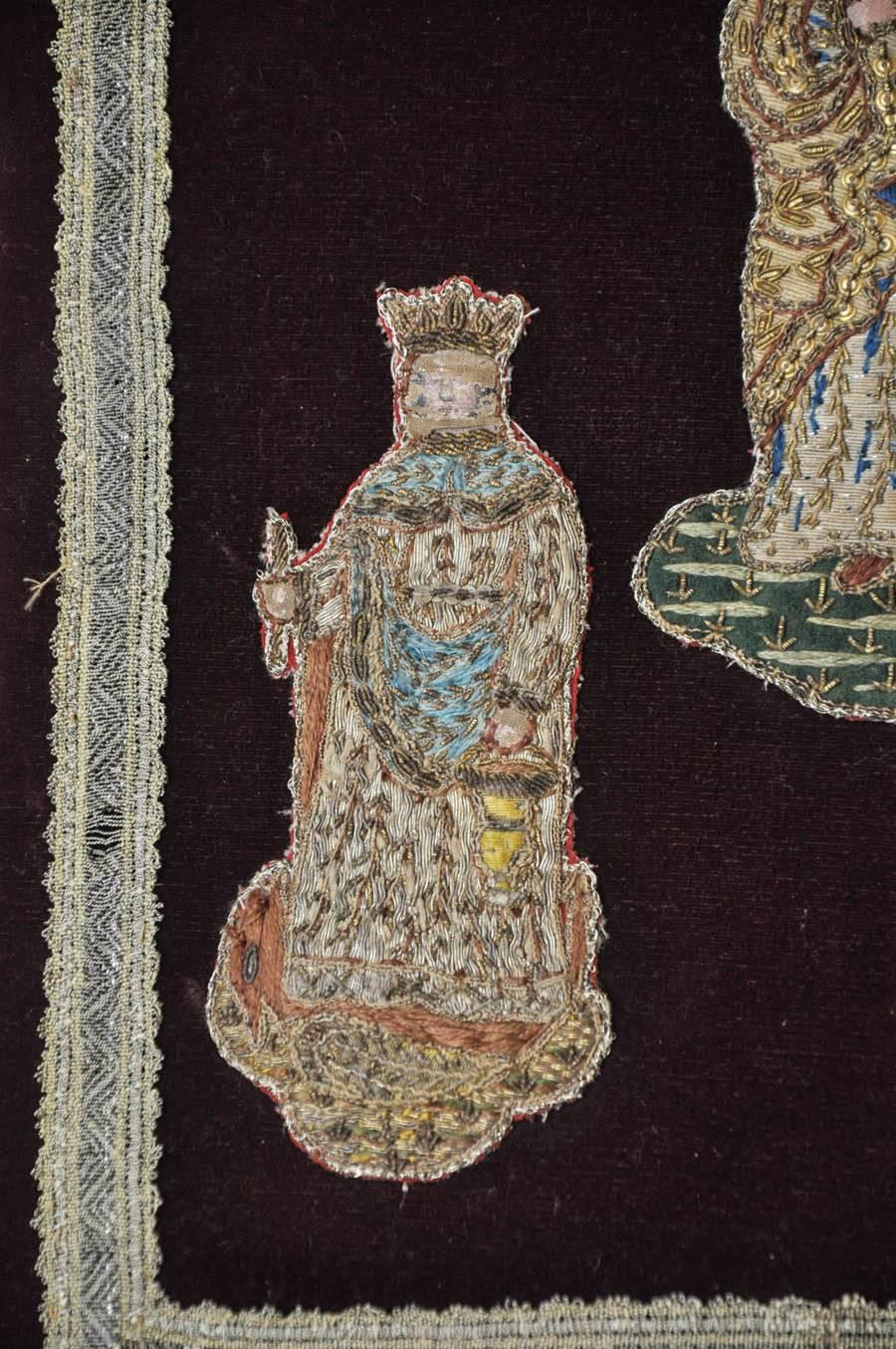 Silk velvet panel depicting three important religious figures fragments from a 18th century vestment with silver-gilt threading.   A crowned Virgin Mary as Queen of Heaven holding the baby Jesus in the center of the panel. On the left is a crowned