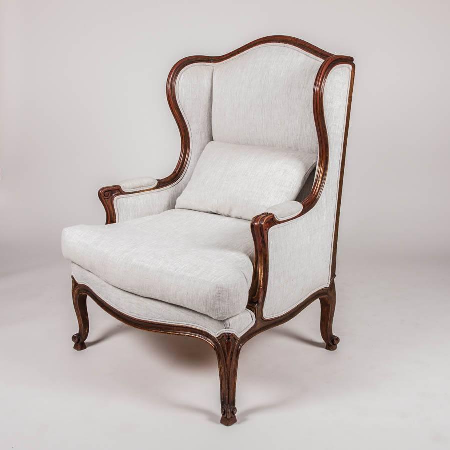 A pair of French bergère à oreilles or wing chairs, carved beech with faint gilt highlights.

Upholstered in Russian linen.

  