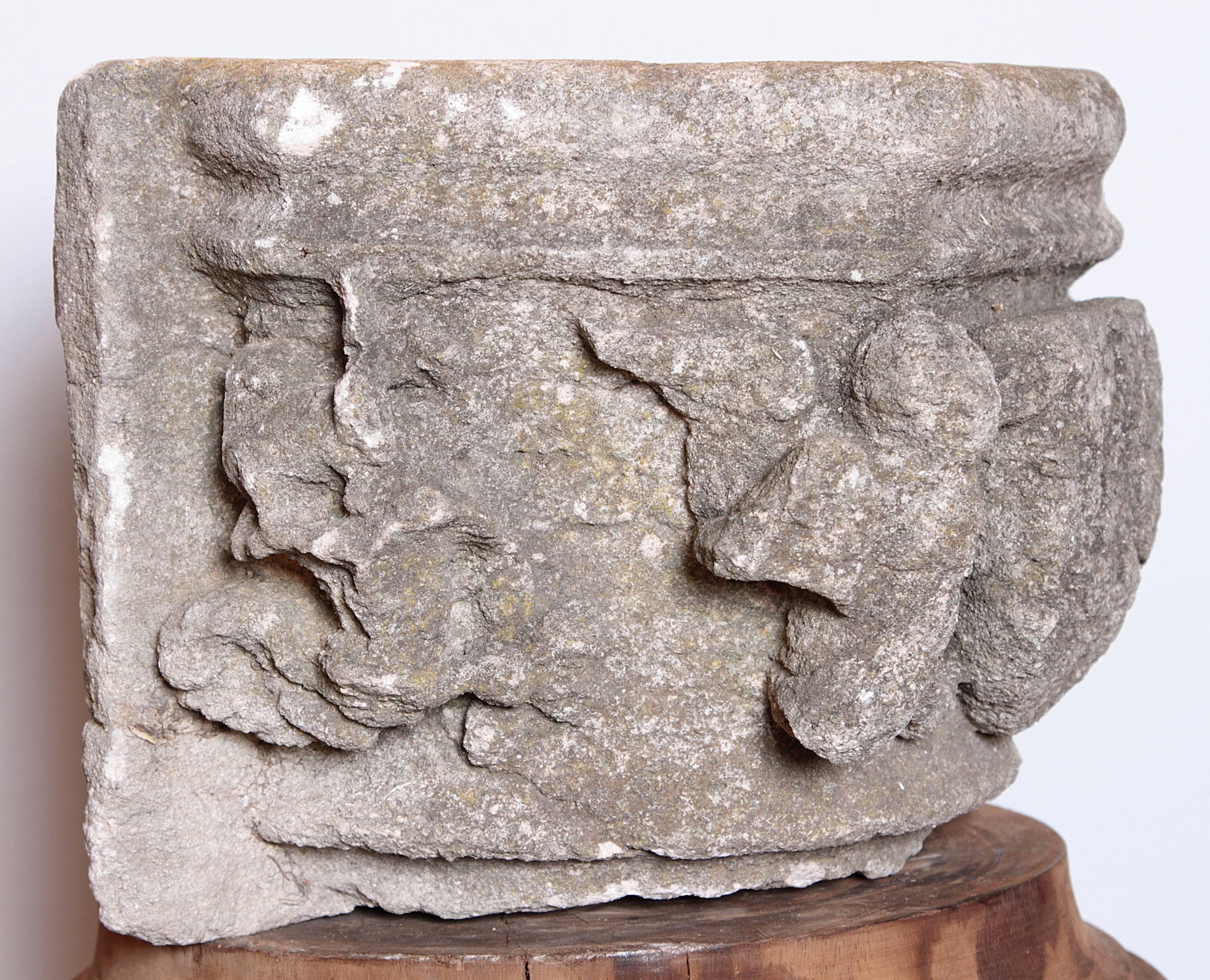 This rare fragment was salvaged from an entryway on a building in Fontvieille, near the city ancient Arles, France. There is a worn and carved center cartouche depicting a very small church with a cross on the roof flanked by deeply carved angels.