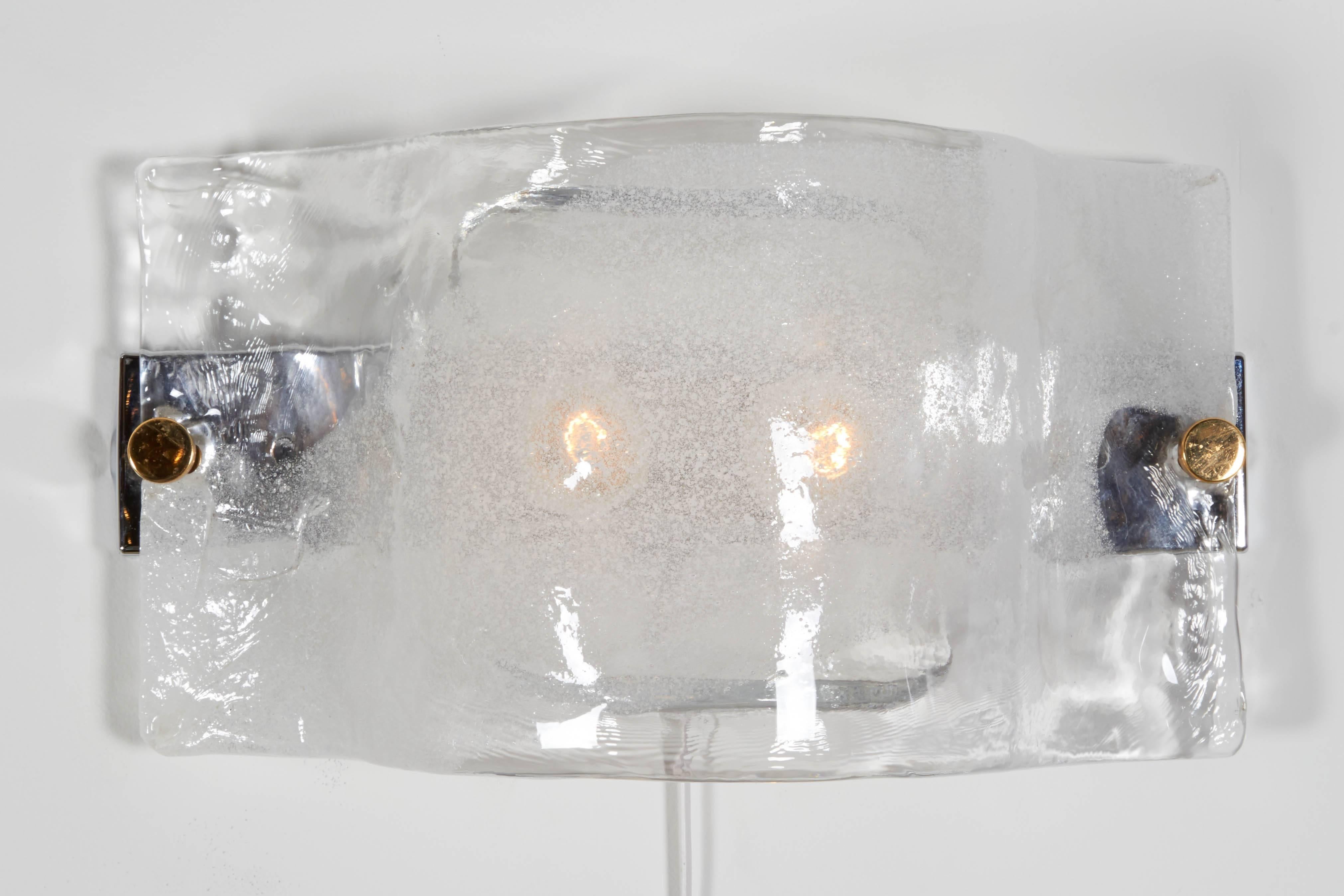 The glass on these Mazzega sconces possess a wonderful floating mist like appearance. They have two glass elements that conceal the bulbs. There are two pairs available.