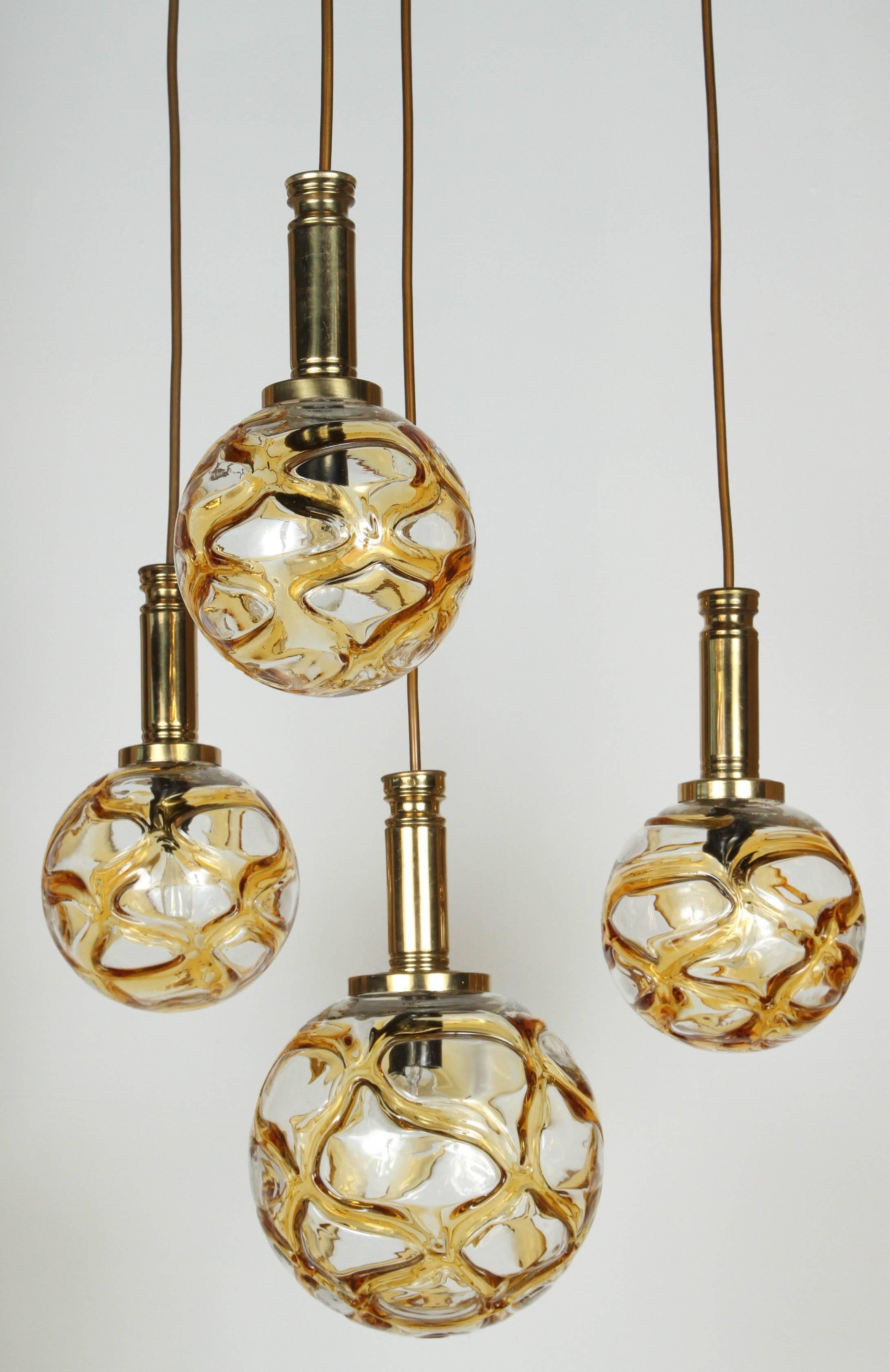 Organic globe fixture by Doria Lighting co.
The polished brass fixture supports 2 different size organic style globes of Amber, yellow and clear glass . Each globe has a single light source which have been newly rewired (Max Watts per bulb).
