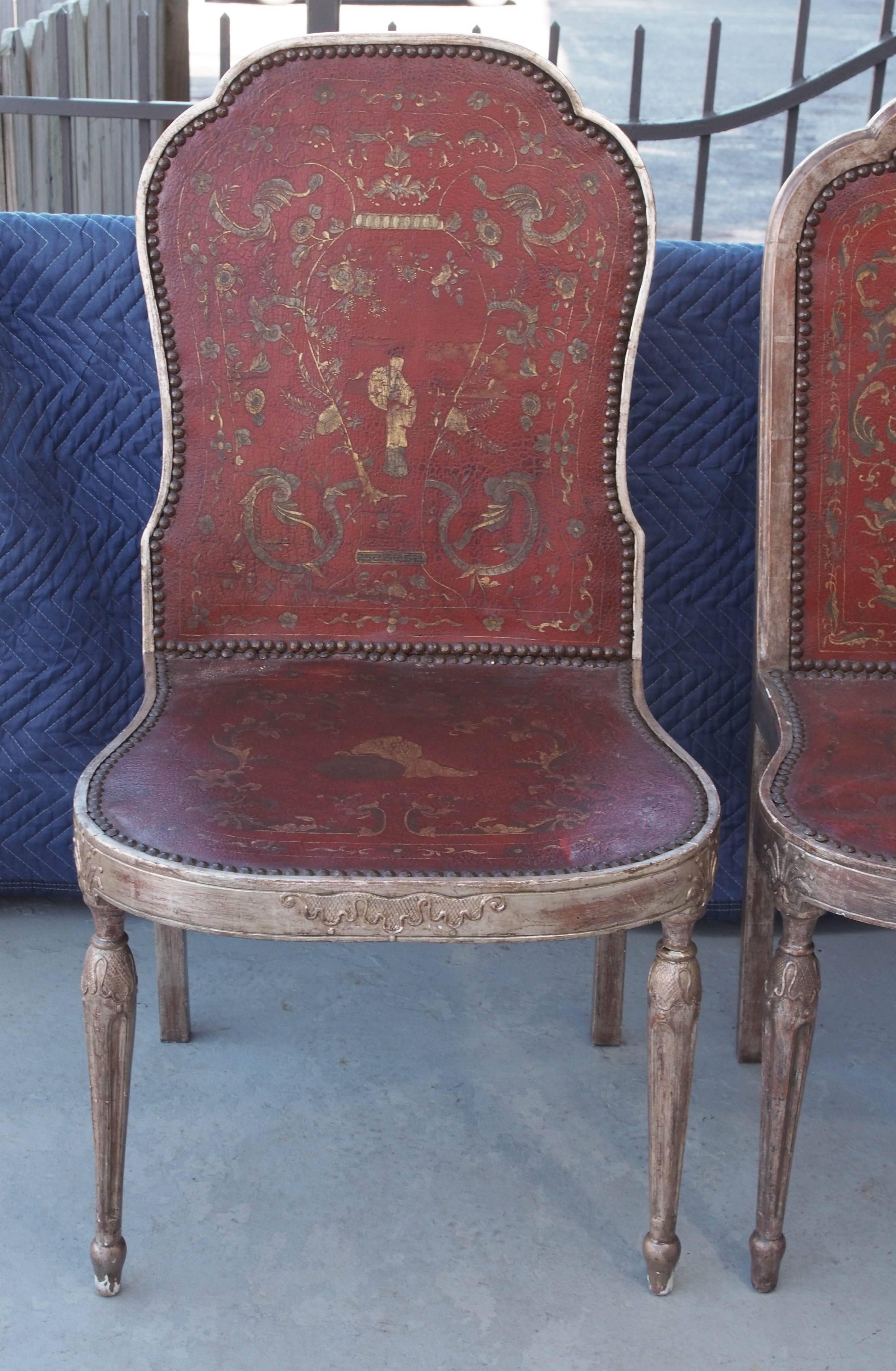 Two sets of four Italian silver gilt dining chairs with leather panels with gilt chinoiserie upholstery. The two sets were made to go together as they are the same except for the back rails are thin on one set and thick on the other.
 