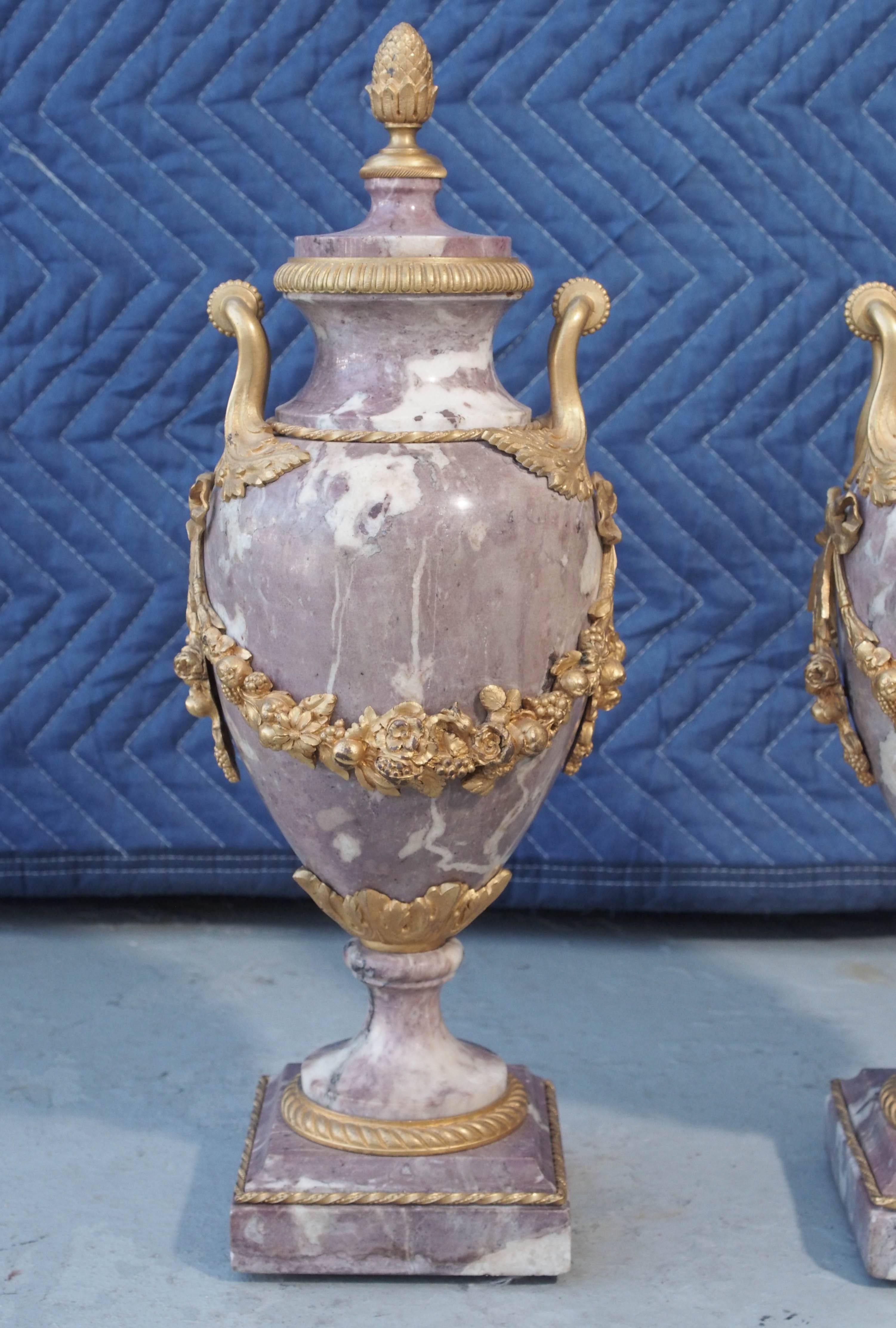 Pair of French gilt bronze-mounted marble garniture with foliate swags and handles with engine turned mounts and finials.