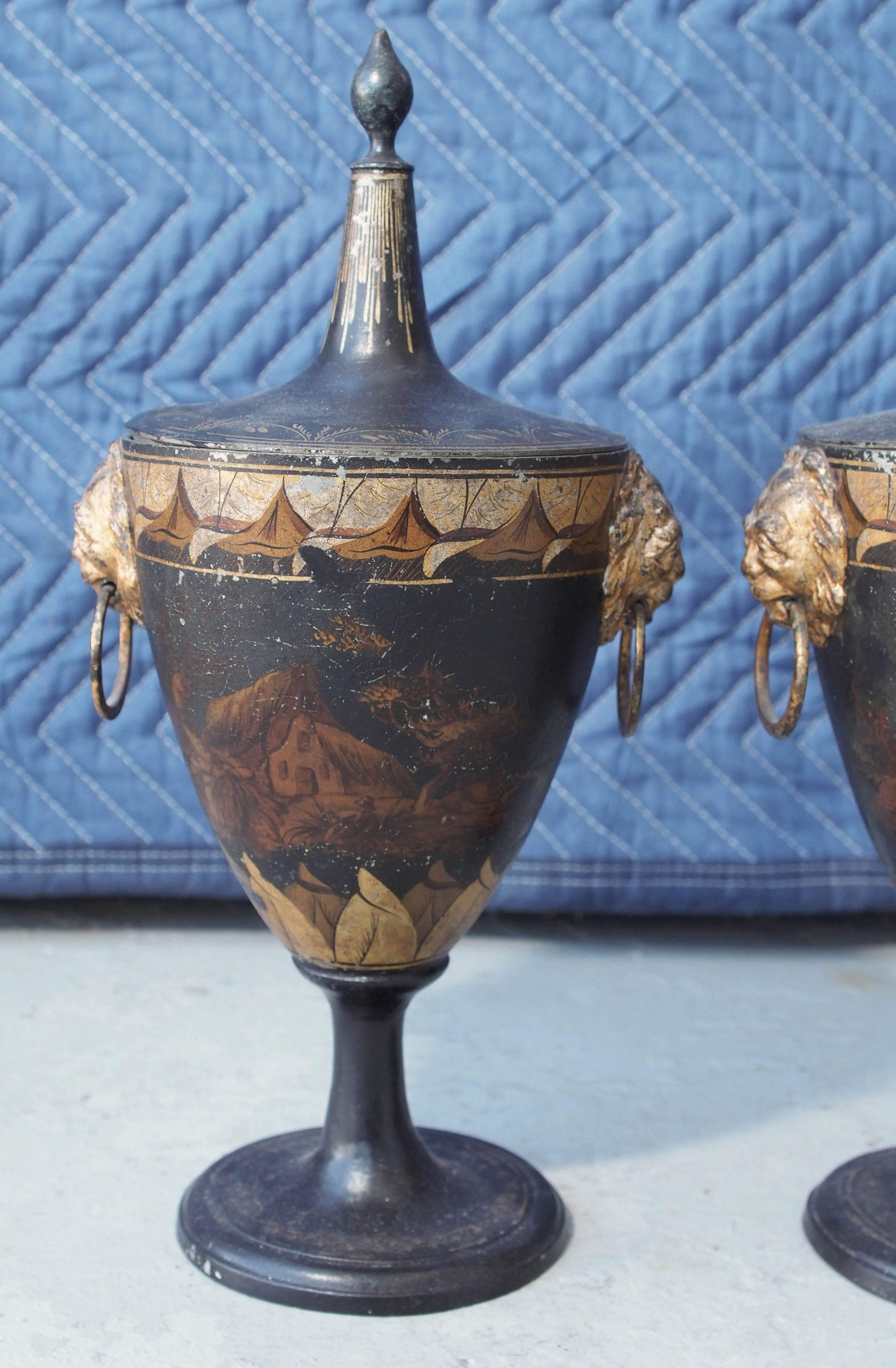 Pair of painted and gilt decorated tole Chestnut Urns with lids. 