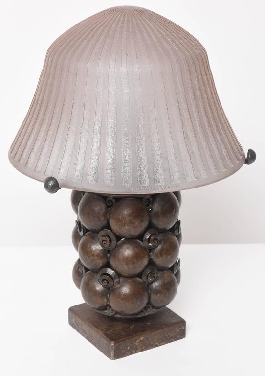 This handsome Art Deco table lamp is attributed to the iconic designer Edgar Brandt. It is bronze with a violet-colored signed Daum Nancy France glass shade. 

Note: Shade dimensions are 7.75" height x 12" diameter.
 Overall dimensions