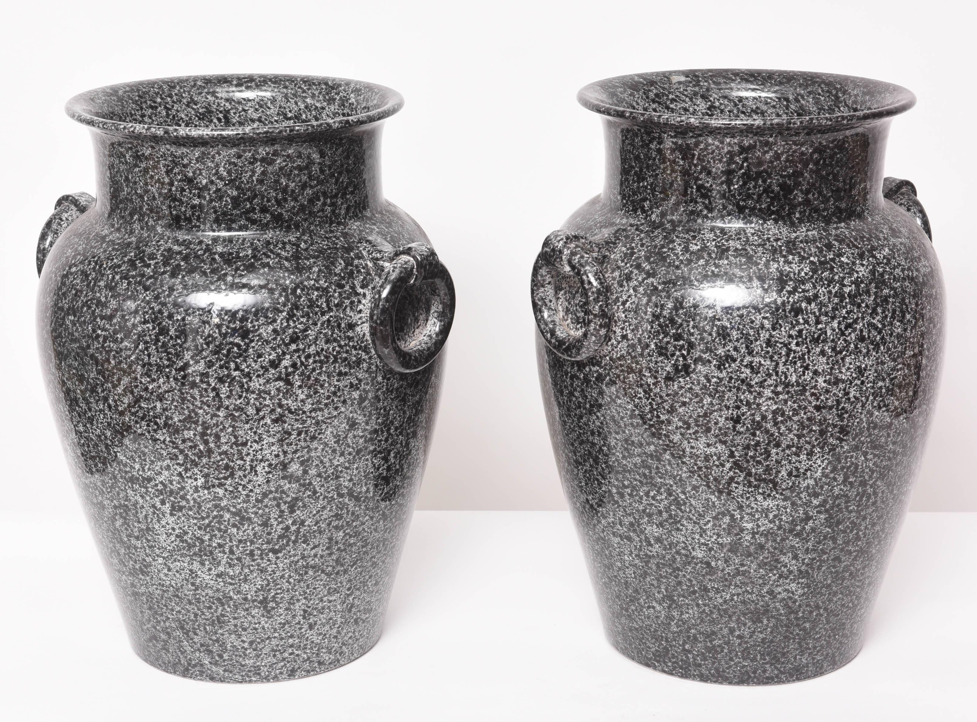 This pair of glazed pottery urns are in a mottled black and gray coloration which resembles porphyry marble.

Note:  They do have a hole in the bottom for drainage or to be made into a lamp.
 
For best net trade price or additional questions