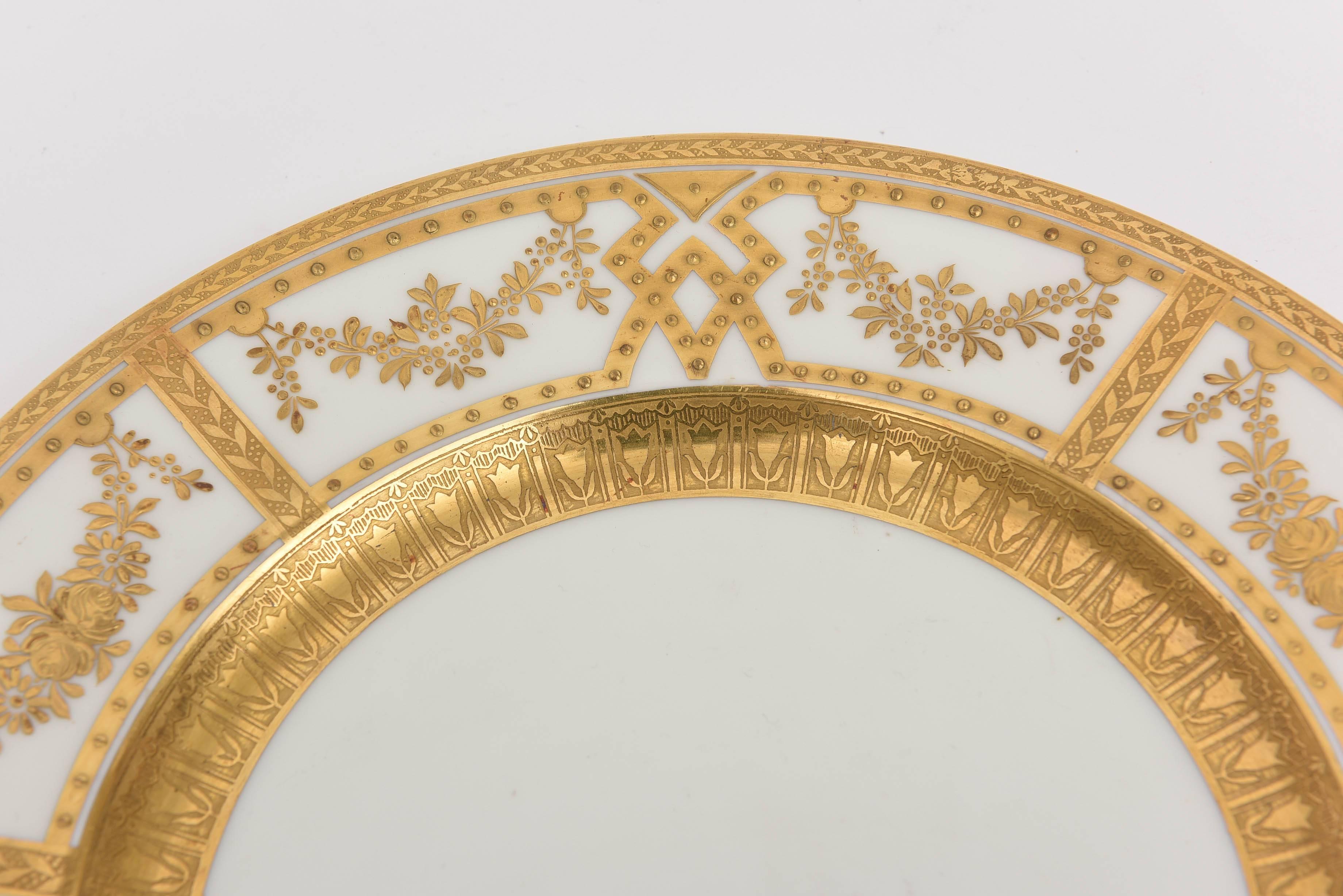 A wonderful custom set of 12 antique English dinner or presentation plates decorated by Crown Sutherland. Lots of hand tooled raised paste gilding in an elaborate design. Decorated on the under side with 24-karat gold also ! Wonderful antique
