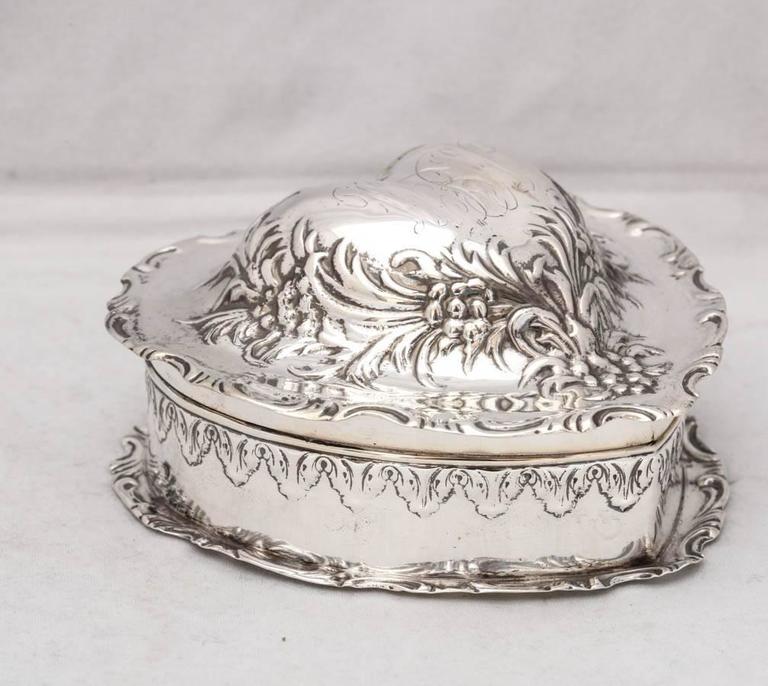 Lovely, Victorian, sterling silver, heart-form trinkets box, The Whiting Manufacturing Company, Providence, Rhode Island, circa 1895. Very, very faint remnants of an old monogram in central cartouche on lid. Measures: 3 1/2
