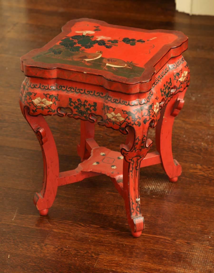 The square top with outset corners and decorated with floral sprays and birds, raised on four scrolling legs joined by a platform stretcher.