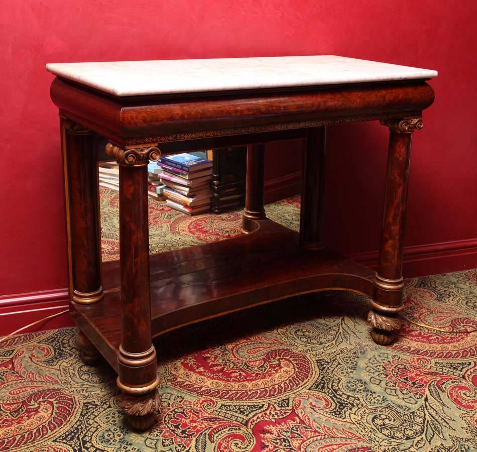 A fine example of New York Classical furniture with choice cuts of finely figured mahogany used throughout.

The white marble top over a convex-molded frieze with a stenciled border; raised on columnar supports with carved gilt ionic capitals; the