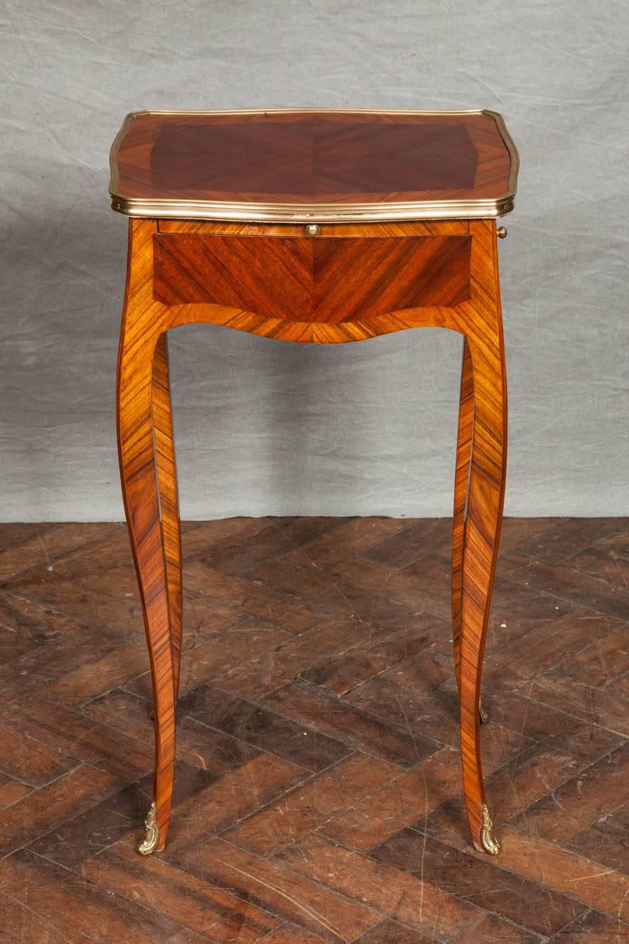 A good quality pair of French kingwood, crossbanded side tables, having a slide and drawer to each. Raised on cabriole legs with ormolu feet.