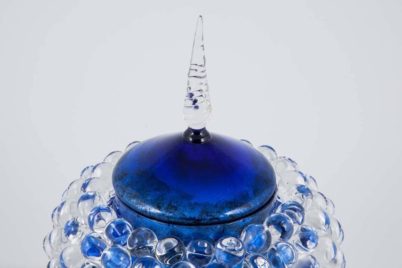 Empoli Jar with Spike, is a unique art glass jar by British glass artist James Lethbridge. Blown glass with gilding on the inside. The outer layer is covered in flameworked decoration and adornment. The piece has a removable top lid.

Initially