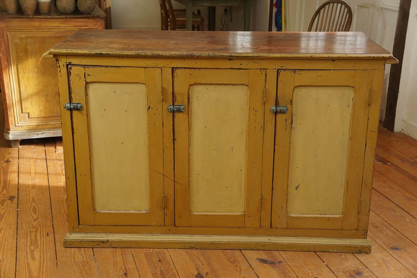 This is a beauty! One of many store counters on display at painted porch. This Canadian piece is two toned in cream and mustard yellow. One side has wrought iron latches where the owner stored his food for sale in this general store. The other side