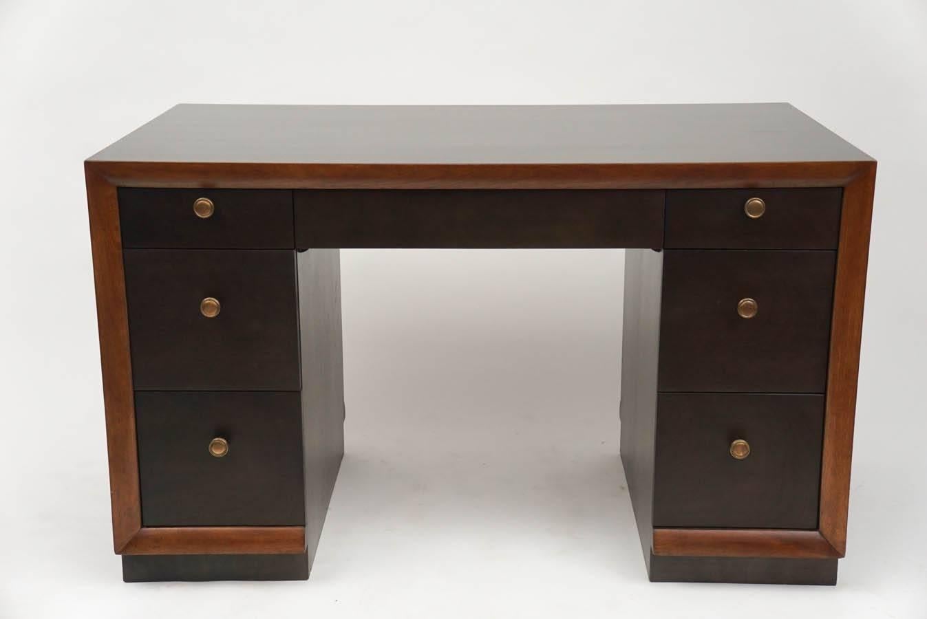 Kneehole desk by T.H. Robsjohn-Gibbings. It has three drawers on each and a center drawer above the kneehole. Produced by Widdicomb. It's missing the original ring pulls but still possesses wonderful style. Vintage condition.