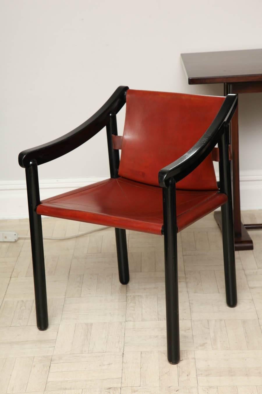 Paire de fauteuils en bois ébonisé et cuir du début du 20e siècle, bras inclinés vers le bas et pieds droits, italiens, vers 1930.