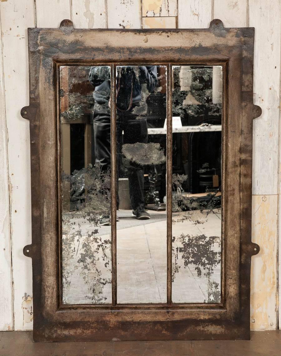 An original antique cast iron window frame glazed with antiqued mirror glass. This characterful mirror has a weathered, Industrial finish. Dimensions include the fixing lugs at the side and top.