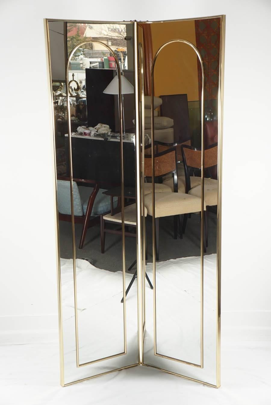A great two-panel floor mirror. The mirror is double sided, with a brass detail inset on one side, and nothing on back. Mirror is in great condition, with slight wear from age.