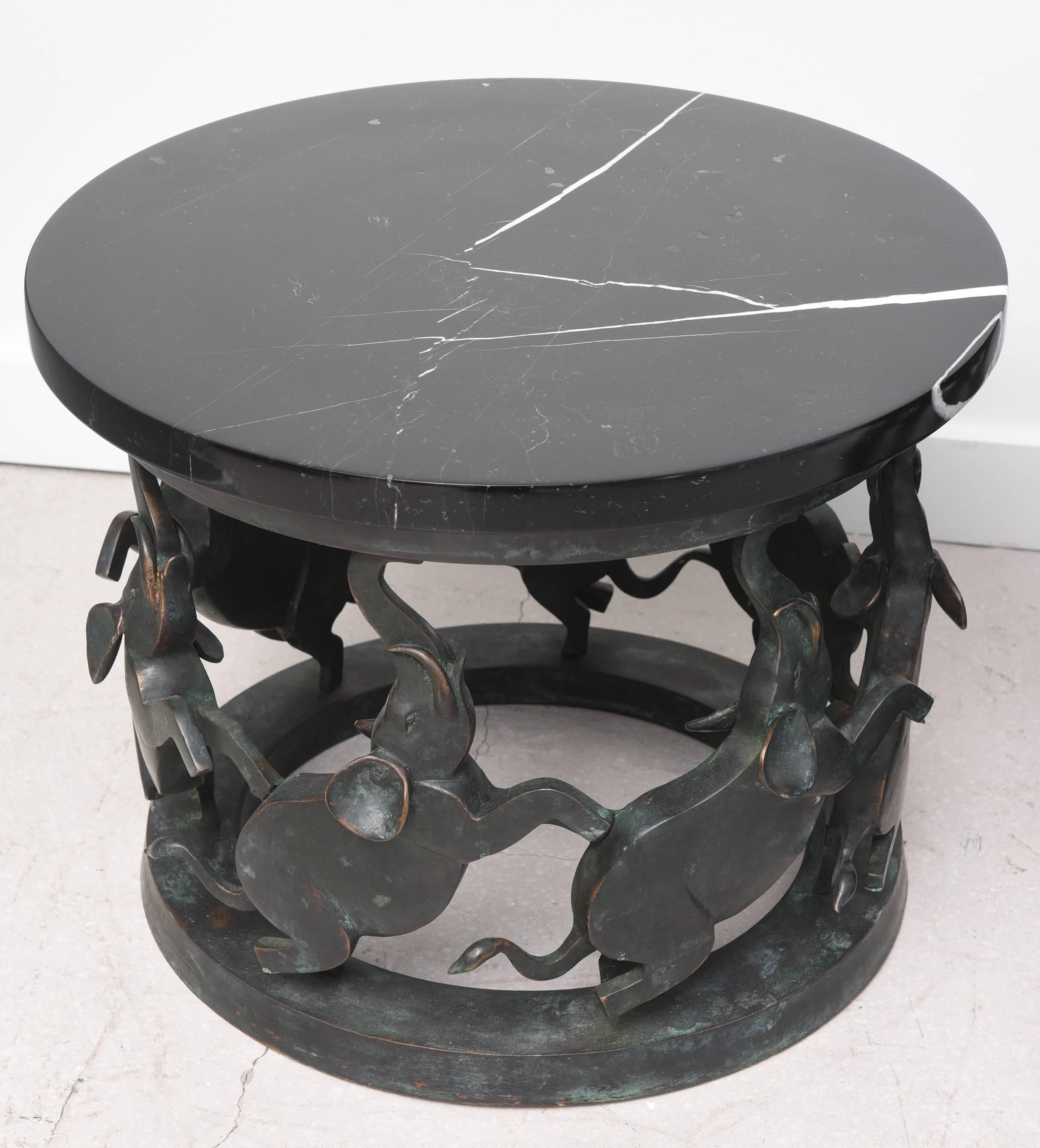 Pair of heavy bronze side tables with stylized elephant motif. The black marble tops are original and removable.