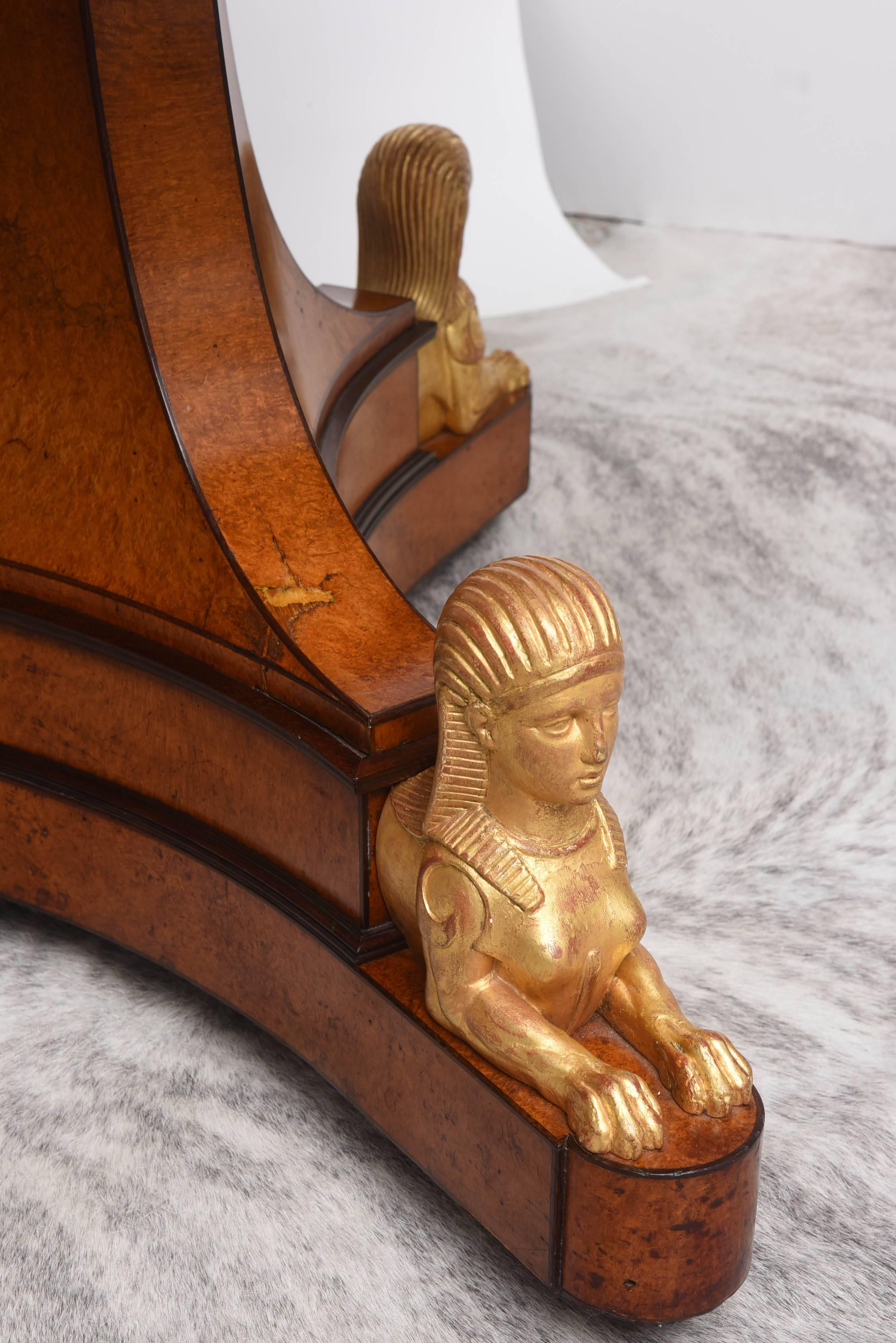 This rare and important circa 1830 French Charles X center table in amboyna and amaranth wood with a circular white marble top above a flared triangular base on caster with gilt-wood Egyptian style sphinxes. 

Provenance: Collection of James Biddle,