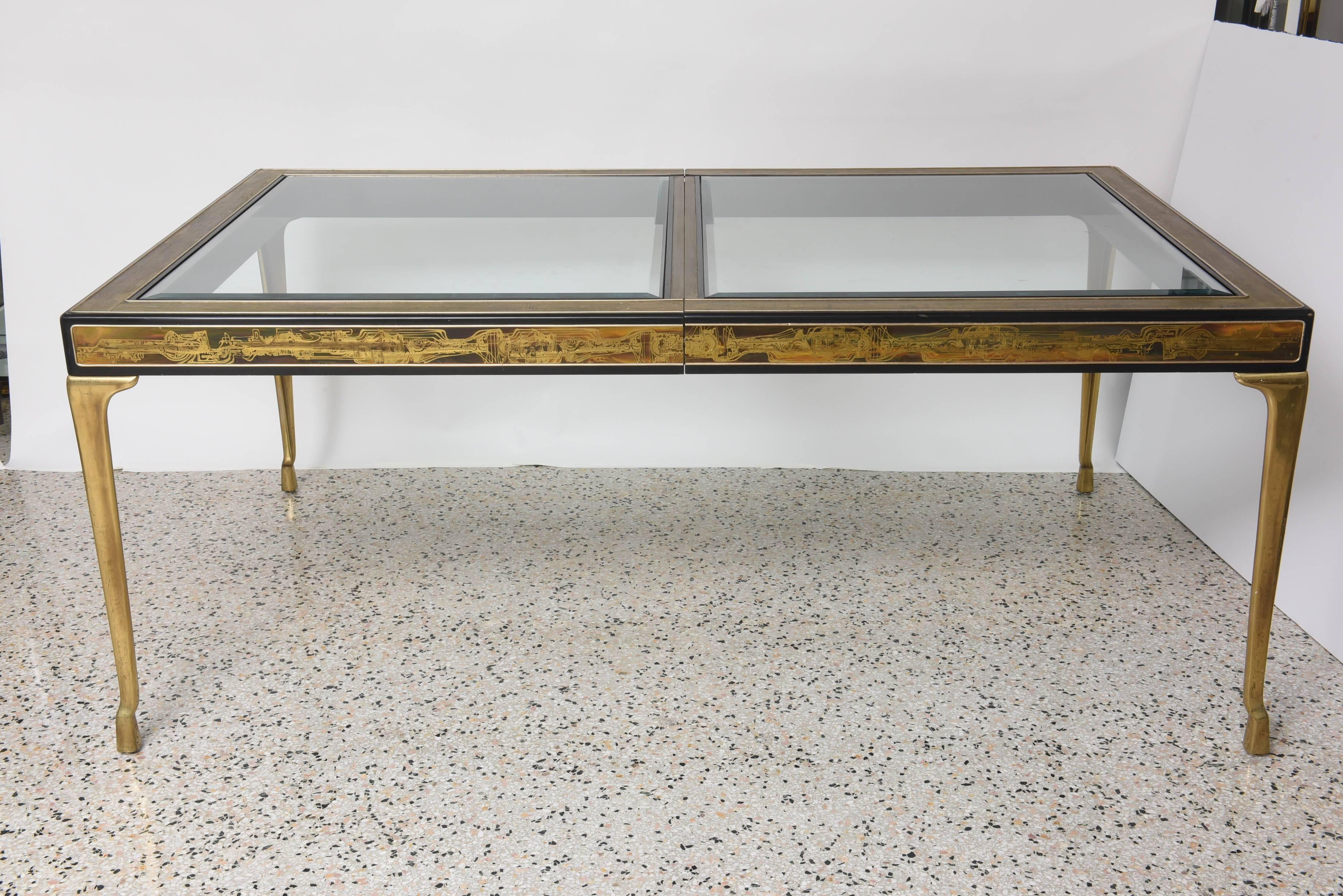 This beautiful American modern dining room table was designed by the iconic furniture designer Bernhard Rohne and was manufactured by Mastercraft furniture in the 1970s. The piece has cast brass legs with stylized doe hooves and a black-lacquered