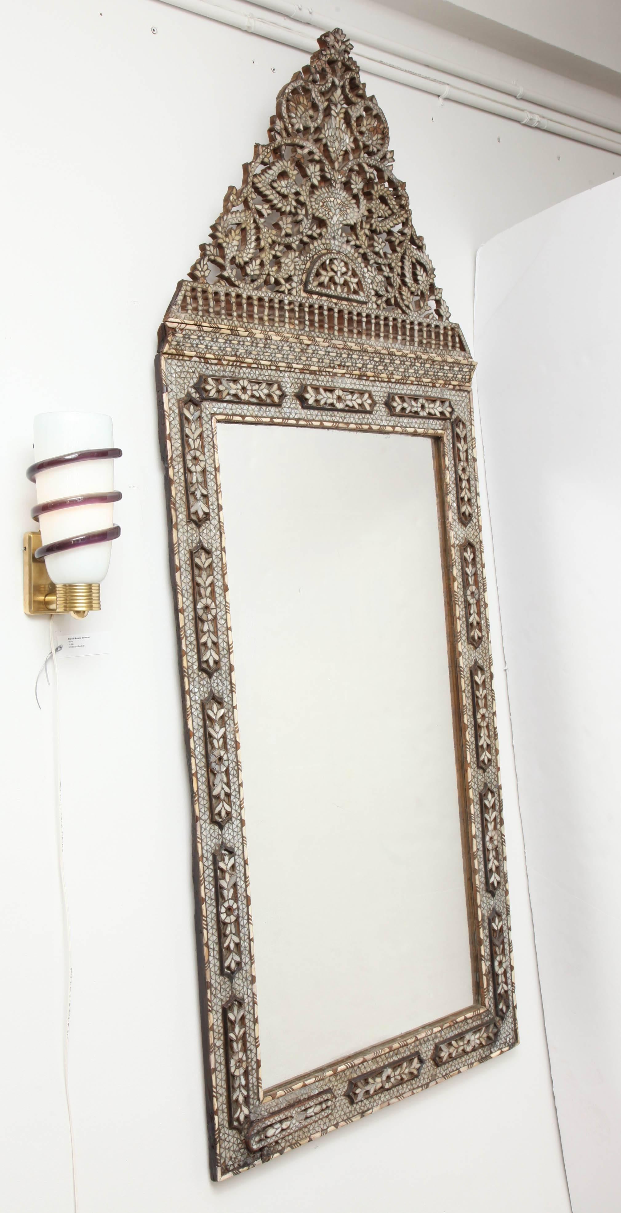 Oversized mother and pearl Syrian mirror with floral and geometric design on the crown. The glass is period from the mid-19th century.