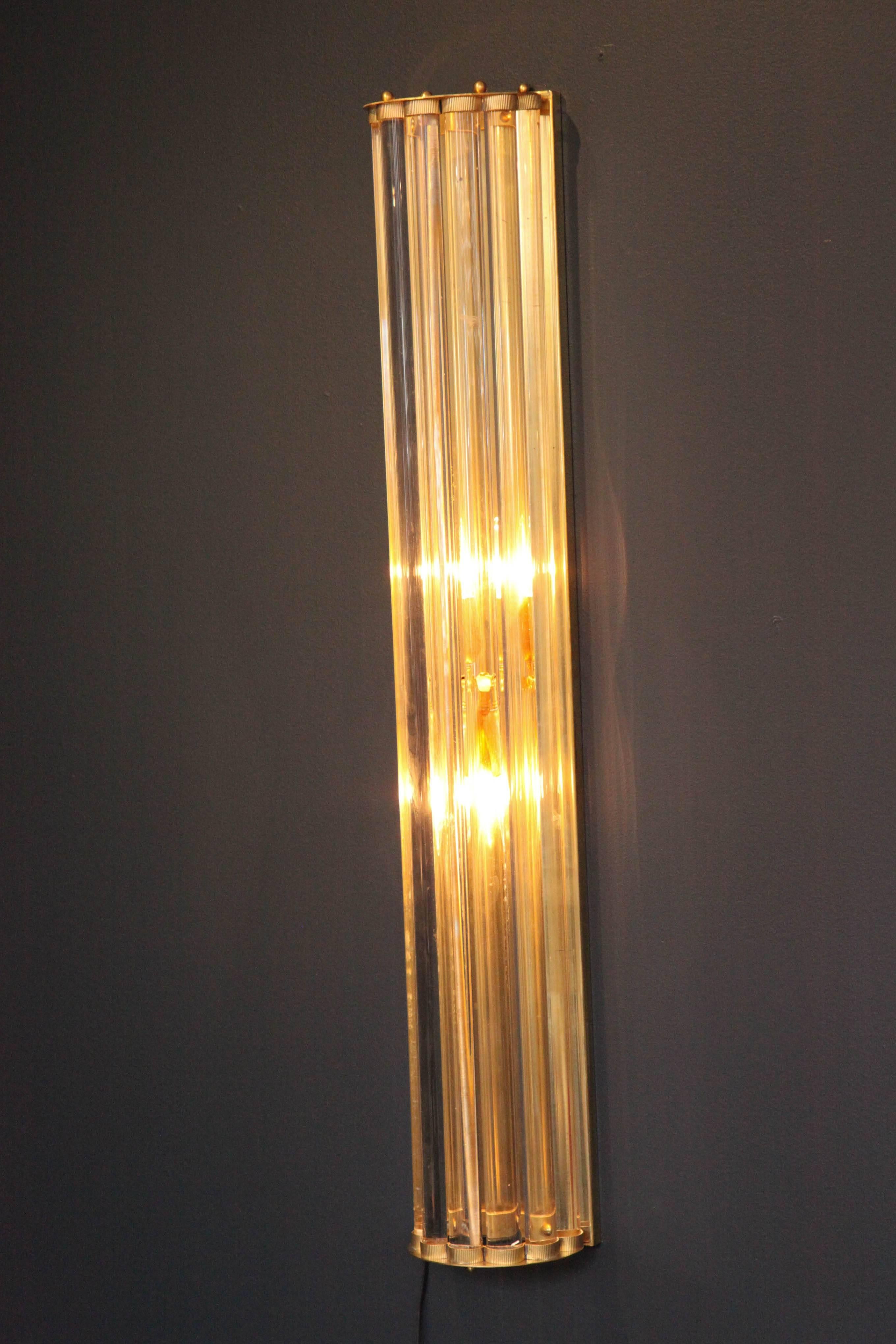 Elegant and classic.  This pair of hand made sconces are comprised of long solid clear Murano glass rods attached to a minimalistic but heavy brass frame.  Light illuminates from within the glass.  Wired for U.S. and ready to hang.

This pair of