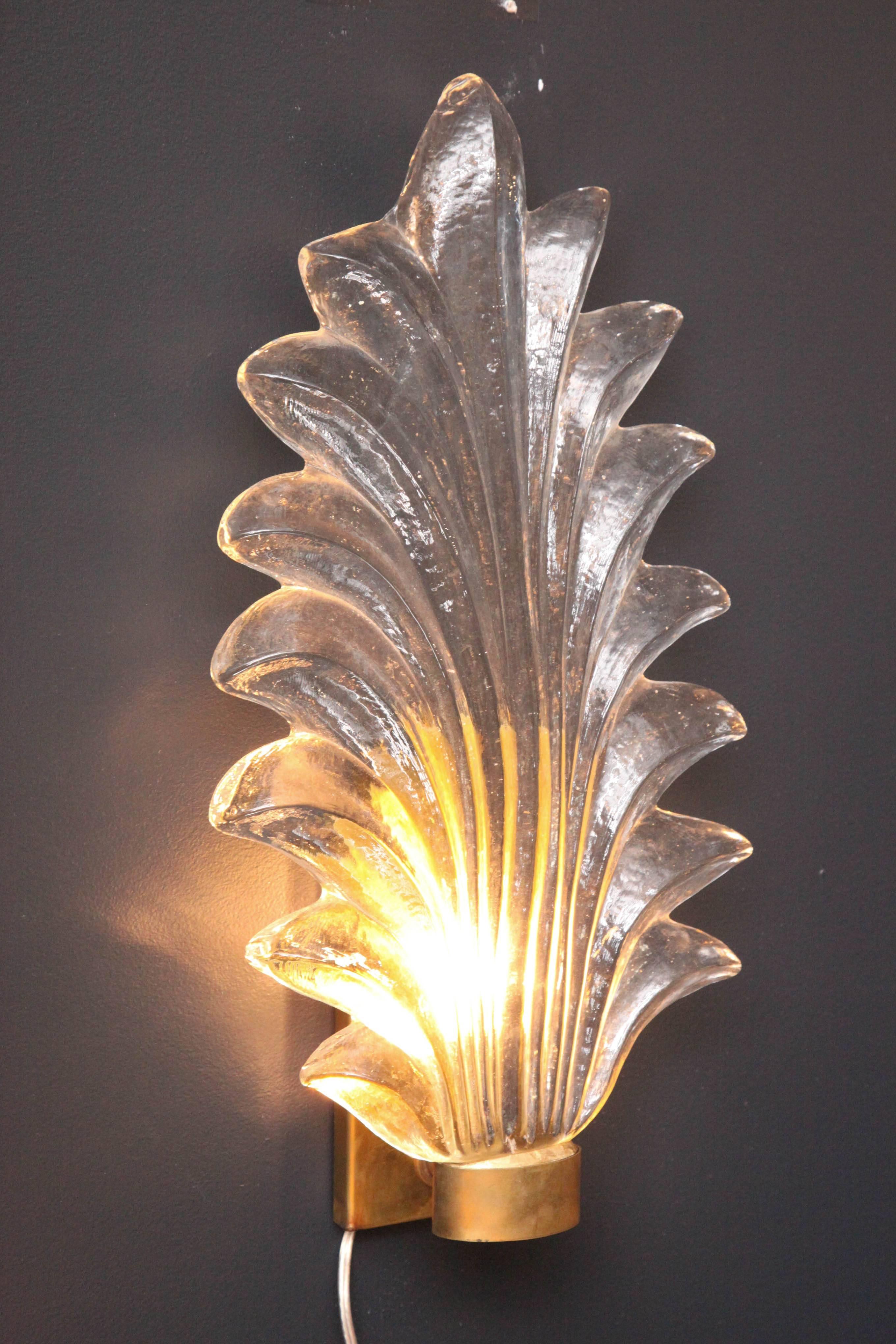 Large pair of clear Murano glass leaf and brass sconces. The leaf shaped hand-casted glass is substantial and solid and rests on a brass ring and frame. Wired for U.S and ready to install. Handmade in Venice, Italy.
  
 