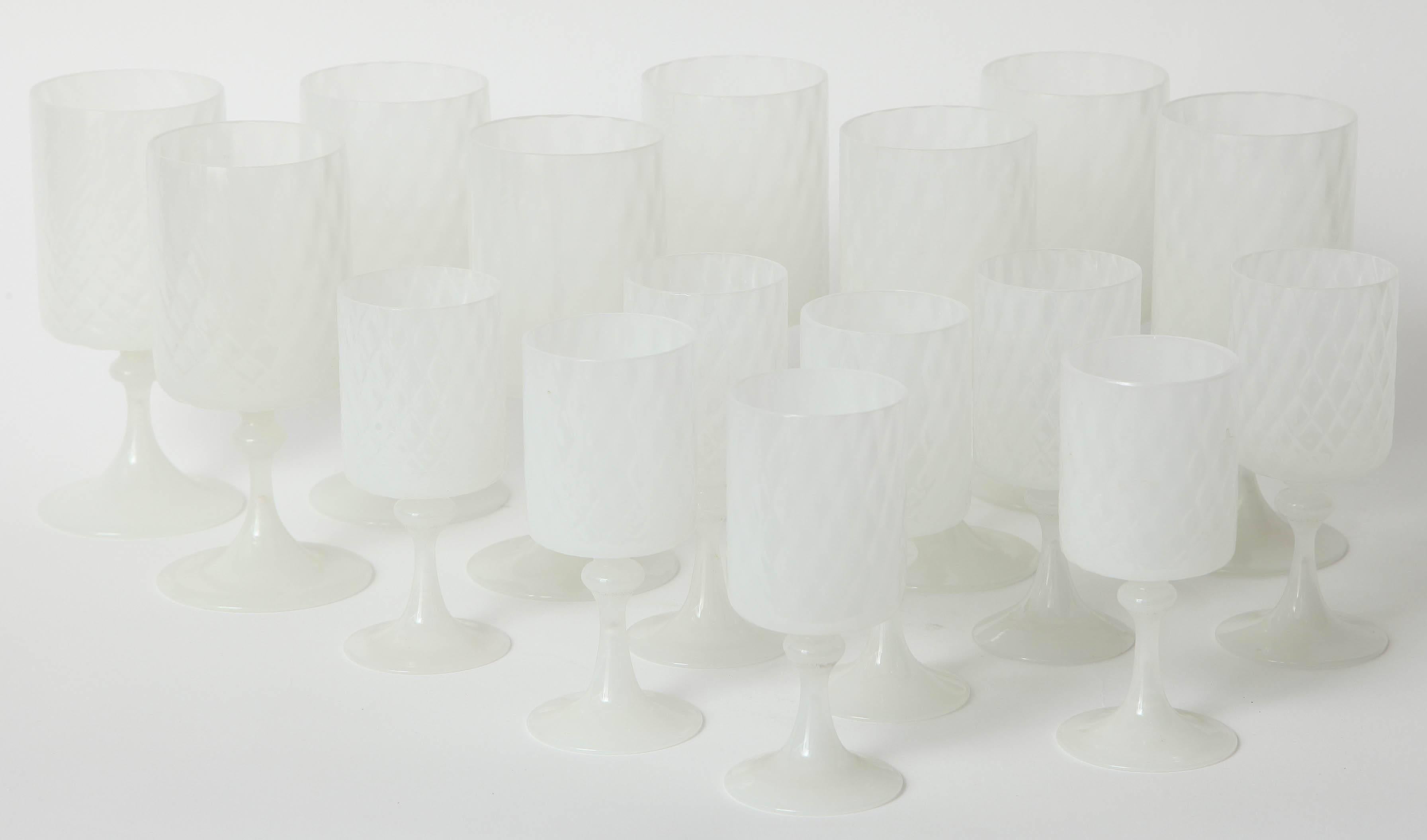 Simple cylindrical bodies on trumpet-shaped stems in translucent white glass blown with a quilted pattern. Unknown maker, Murano, 1960s. Set of eight red and eight white wines. Red wines 3