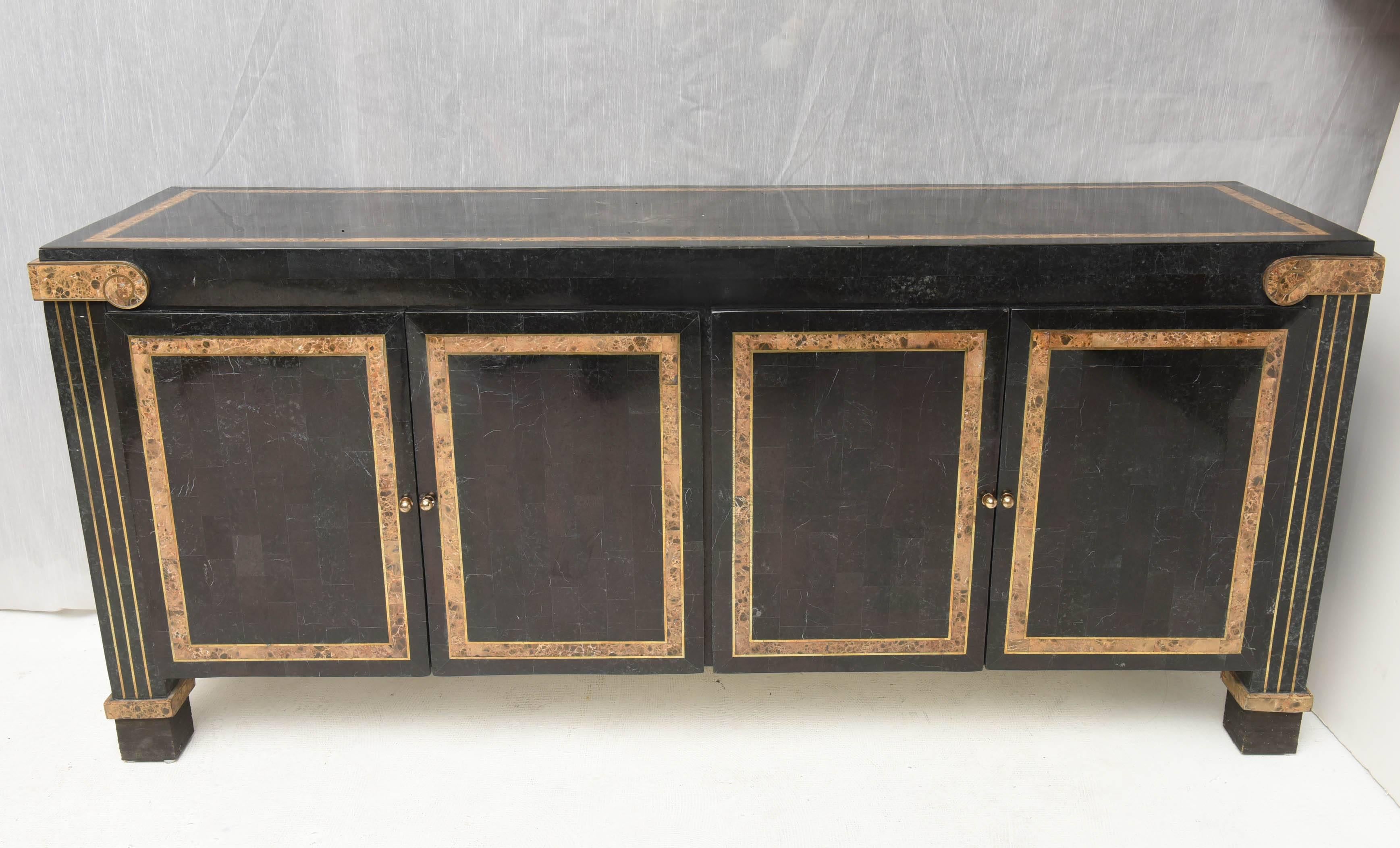 Elegant Mid-Century sideboard, neoclassical design.
 American piece of furniture in tessellated marble, by Maitland-Smith, this sideboard is inlaid with accents in bronze and with a lighter stone contrasting with the darker marble.
four doors on the