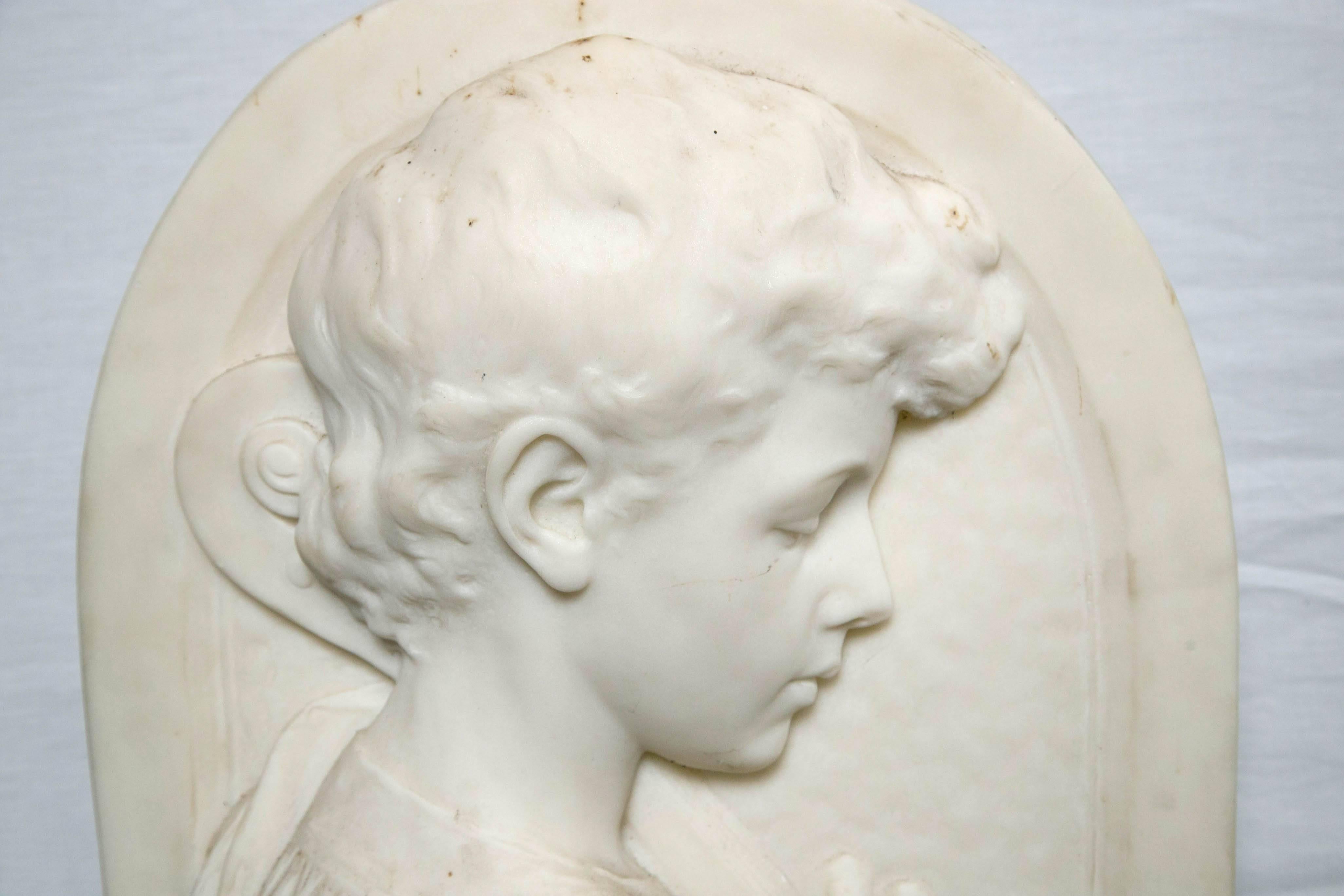 This signed white marble plaque depicts a young boy playing the Cello. It is signed Wm. Couper NY. (William Couper born Norfolk, Va. 1853, died 1942. he retired from sculpting in 1913).
This work entitled 