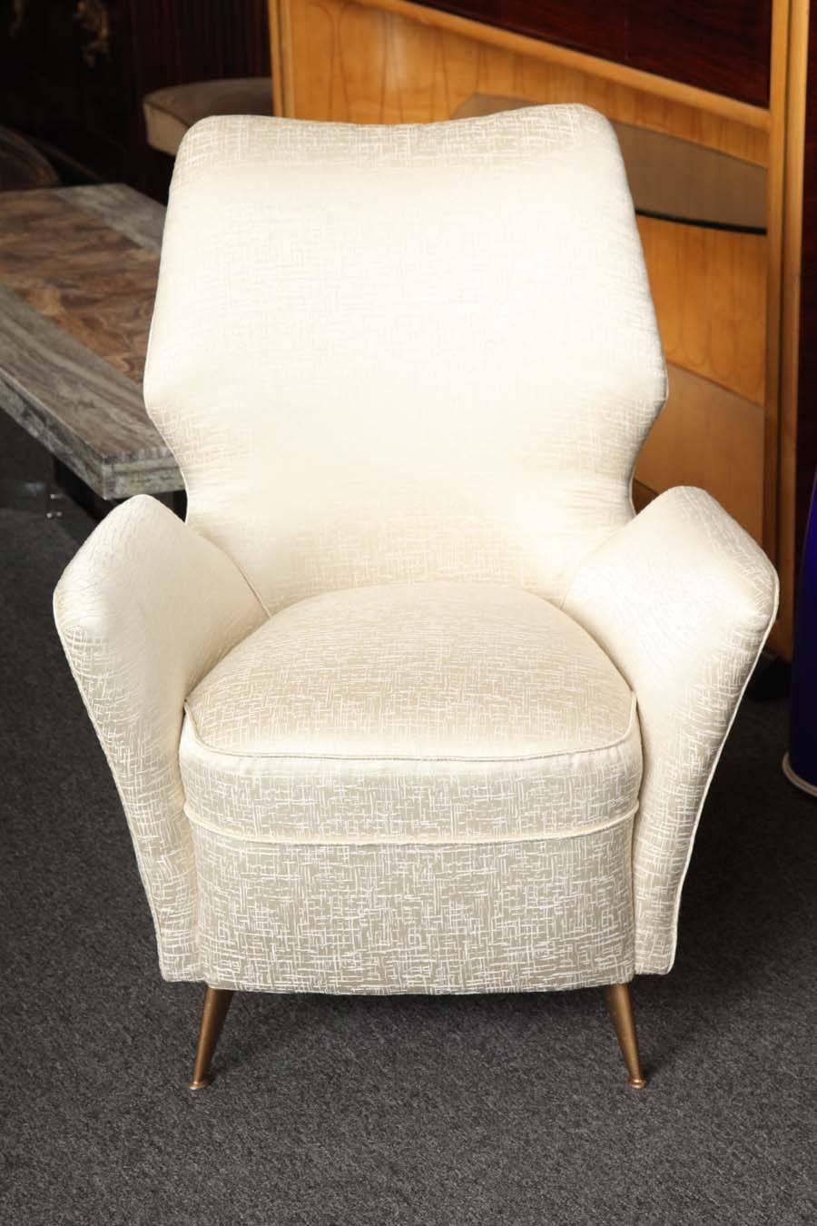 Stunning pair of high back armchairs made in Milan 1955 in a white on white fabric. Legs in gold gild iron, great quality and wonderful feather edge form, very comfortable.
 