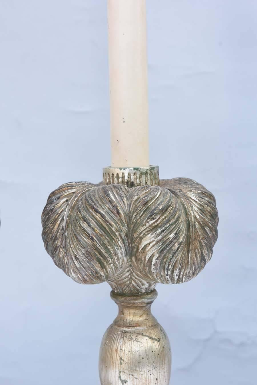 Pair of lamps, of carved, silver gilded plaster-of-paris, each having a balustrade shape, surmounted by plumes, on round, foliate-carved base, and octagonal painted plinth.
