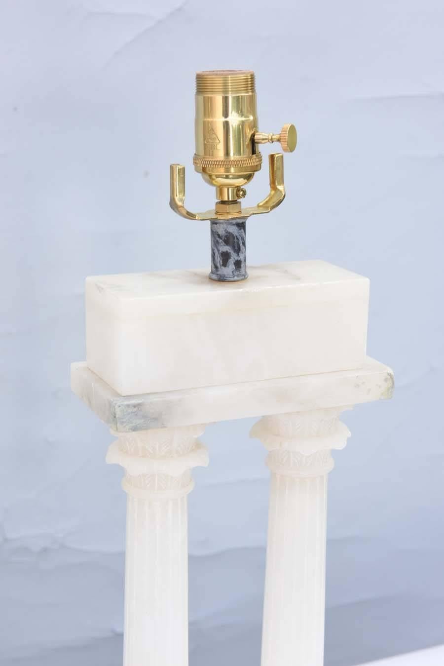 Pair of neoclassical style lamps, of carved alabaster, each a fluted column, with Corinthian capital, supporting a rectangular frieze, lamped on black marble bases.

Stock ID: D9287