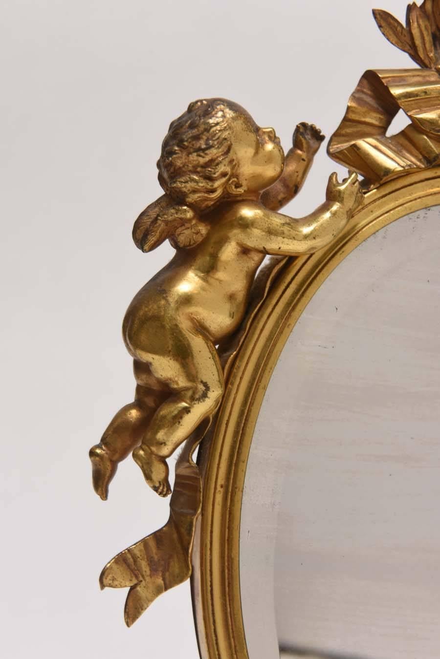 Very sweet Dore bronze vanity mirror adorned with garlands and putti on a Carnelian marble base.