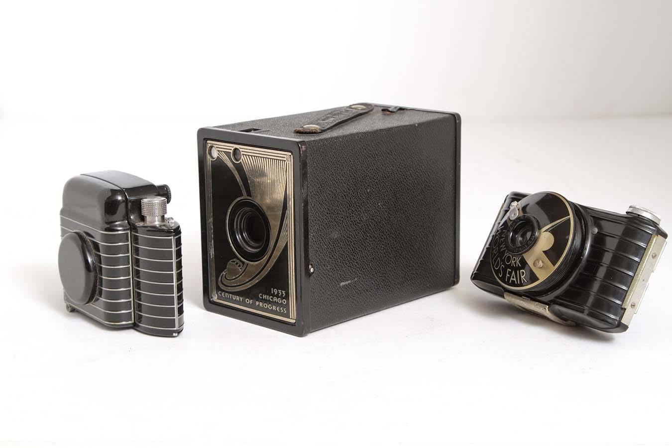 Nice set of 1930s Walter Dorwin Teague embellished designs for Kodak.

The cast aluminum black-enameled speed-lined Bantam is an iconic Art Deco Teague form from 1936-1948. An early streamline clam-shell camera design, making it pocket-portable, a