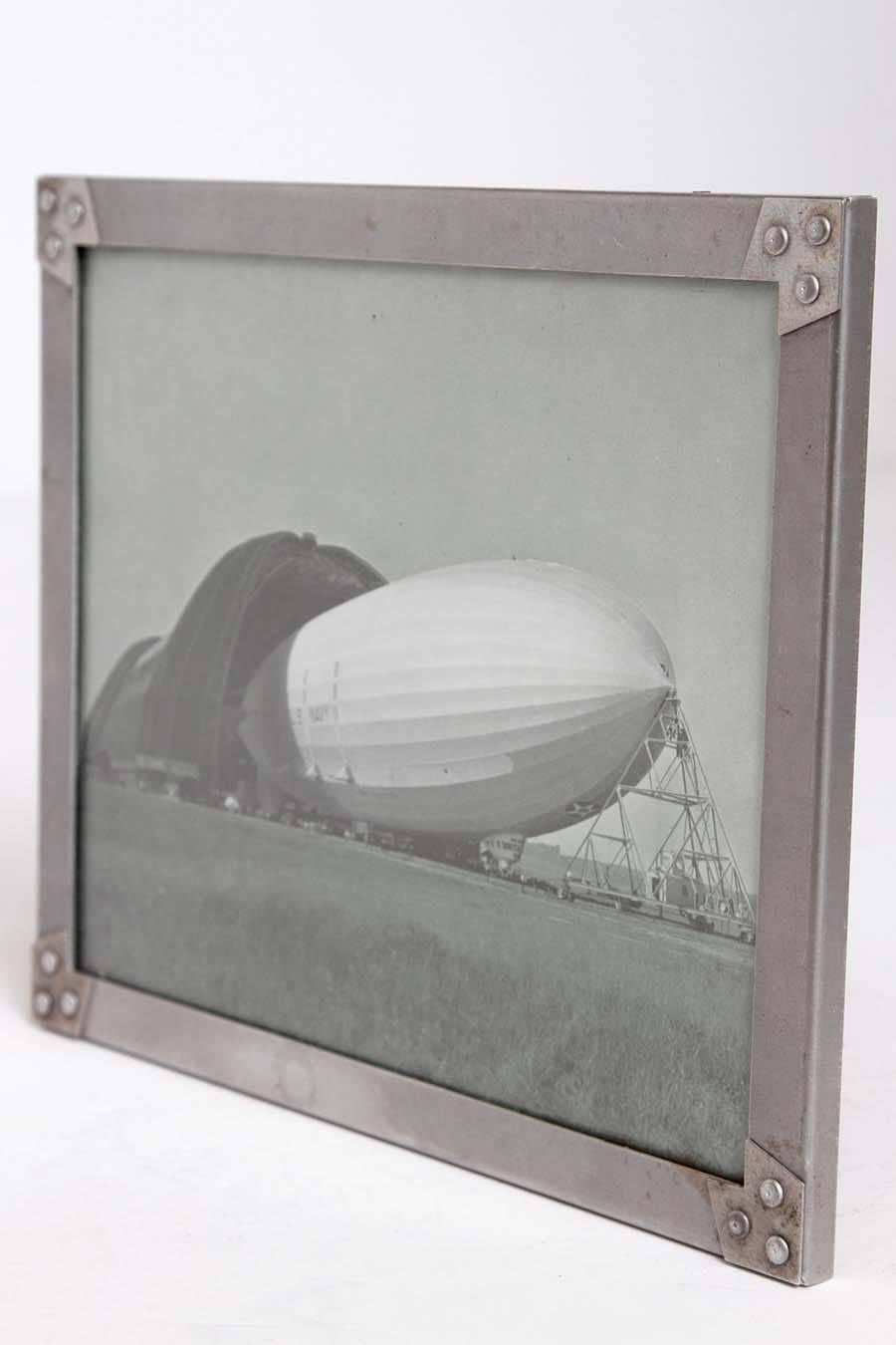 Machine Age Art Deco USS Akron Goodyear Zeppelin Duralumin Framed Litho  Price Reduced from $1500

Unusual smaller size and opposite view from the Margaret Bourke - White signed photo version.
The frame corners are constructed from duralumin