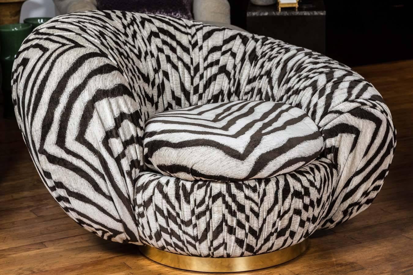Lounge chair on swivel with loose down feather blend seat cushion and gathered fabric body on brushed brass base. Fabric is highland court zebby or onyx. 83% Rayon/12% Polyester/5% Cotton.