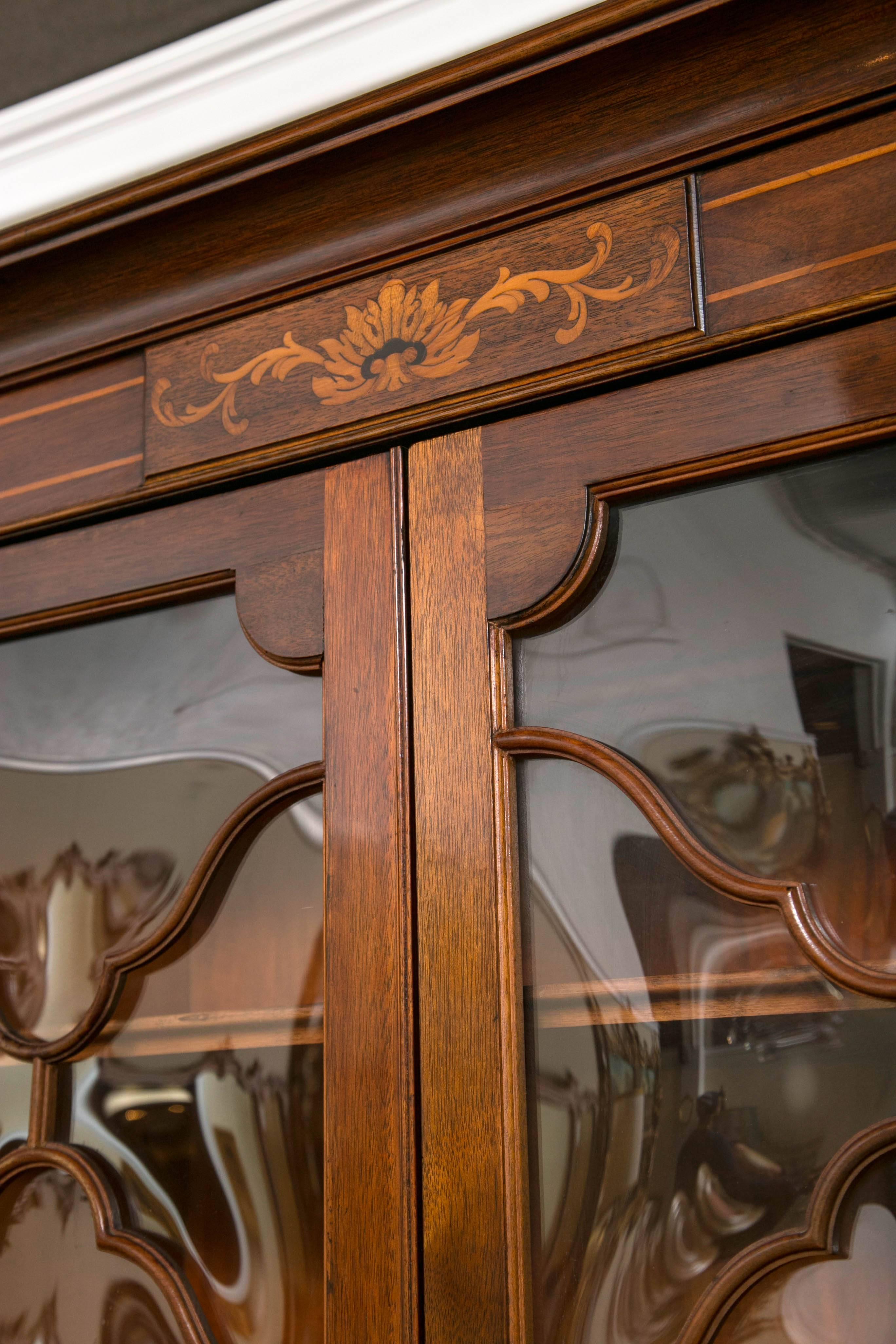 Georgian style Saginaw breakfront bookcase cabinet. This fine crotch mahogany breakfront bookcase is simply a wonderful example of the Georgian Era. Made by the Saginaw Furniture Company. This is a two-piece cabinet.