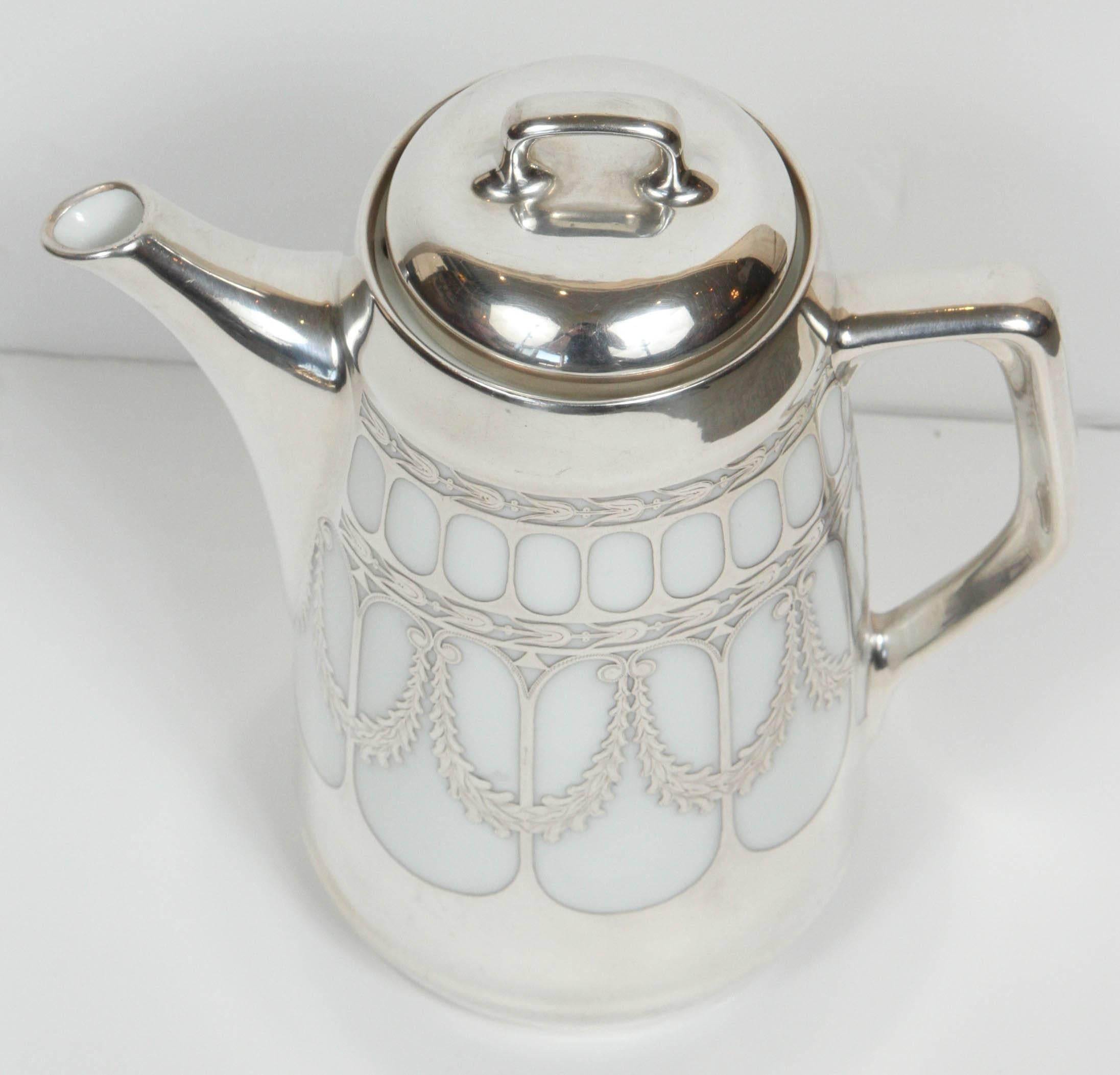 Vintage white porcelain with sterling silver overlay coffee pot from Germany, circa 1910-1920.