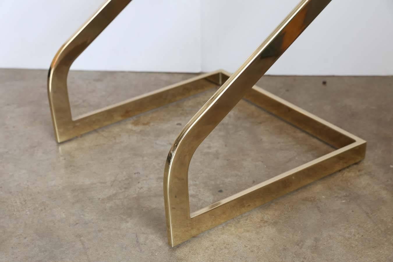 Offered is a shiny lacquered brass and glass square petite side table with a unique and sexy curved base by Design Institute America .  Light weight yet sturdy and balanced.