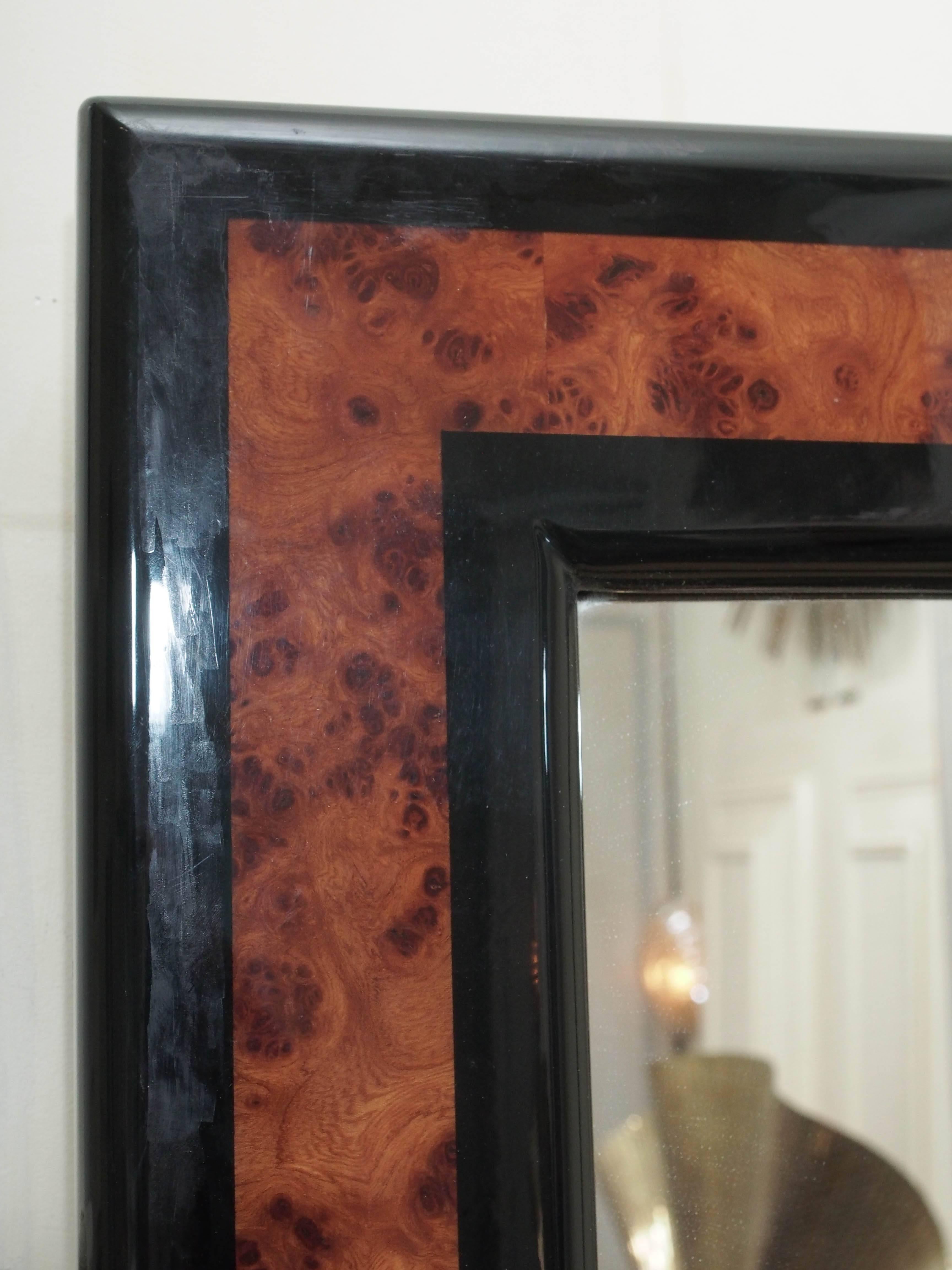 A pair of French mirrors, burled and ebonized wood frames, circa 1969. The glass and frames are in excellent condition, retain their striking luster. 
35 inches wide by 46 inches high by 1 1/2 inches deep.