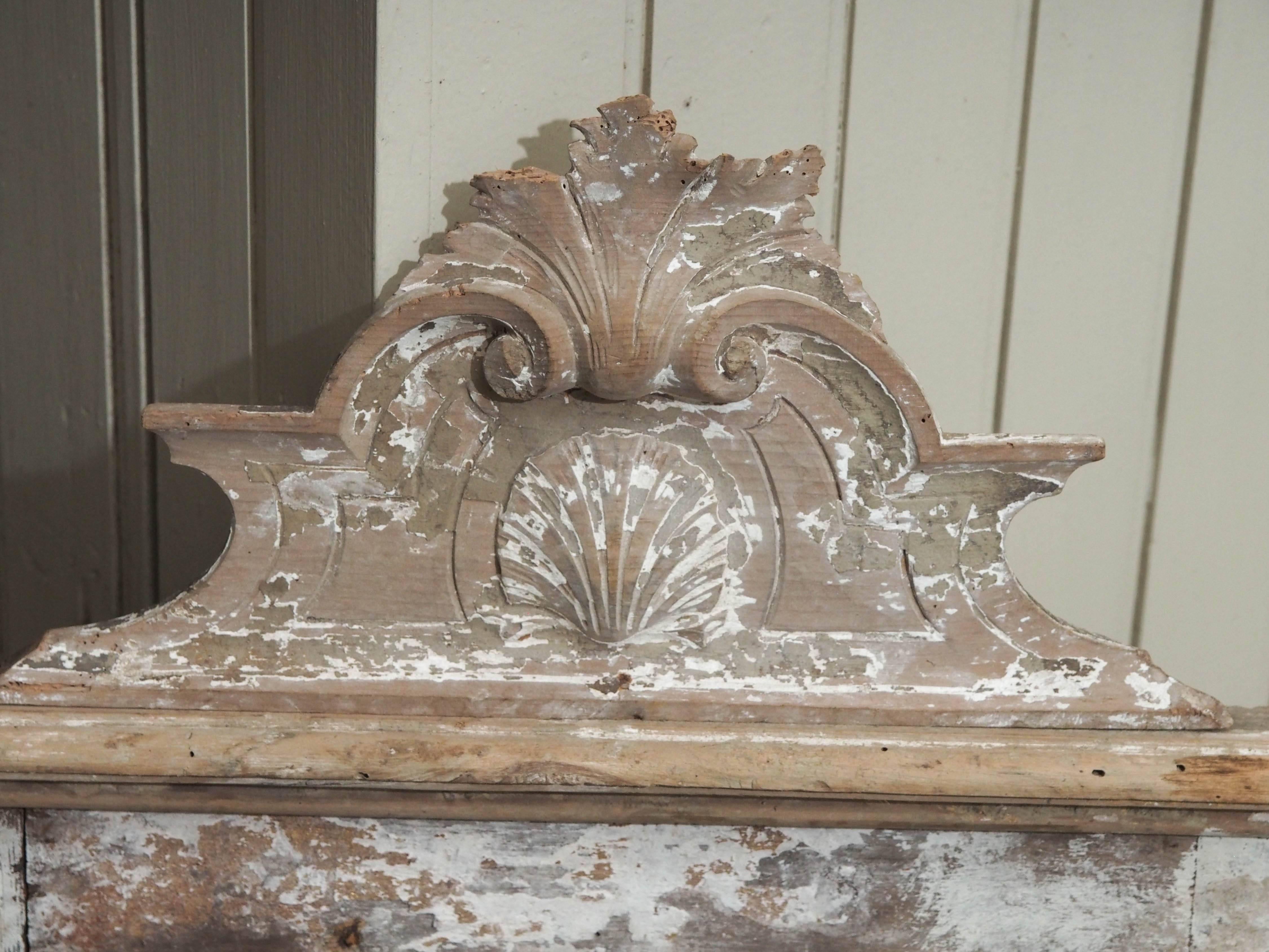 An original mercury glass mirror set into a painted wood frame featuring scroll work and leaf motifs. This piece would be lovely on a mantel (fireplace) piece or a shelf in an elegant space.
