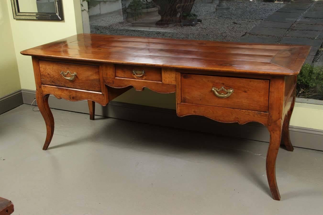 An exceptional French fruitwood writing table or desk, circa 1830. It stands on graceful curved legs and has an elegantly shaped apron. Excellent color, carving and condition.
