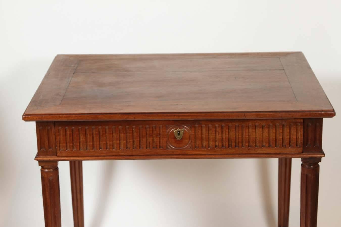 An Italian neoclassical walnut side table with a single fluted drawer on raised tapered legs, circa 1800.