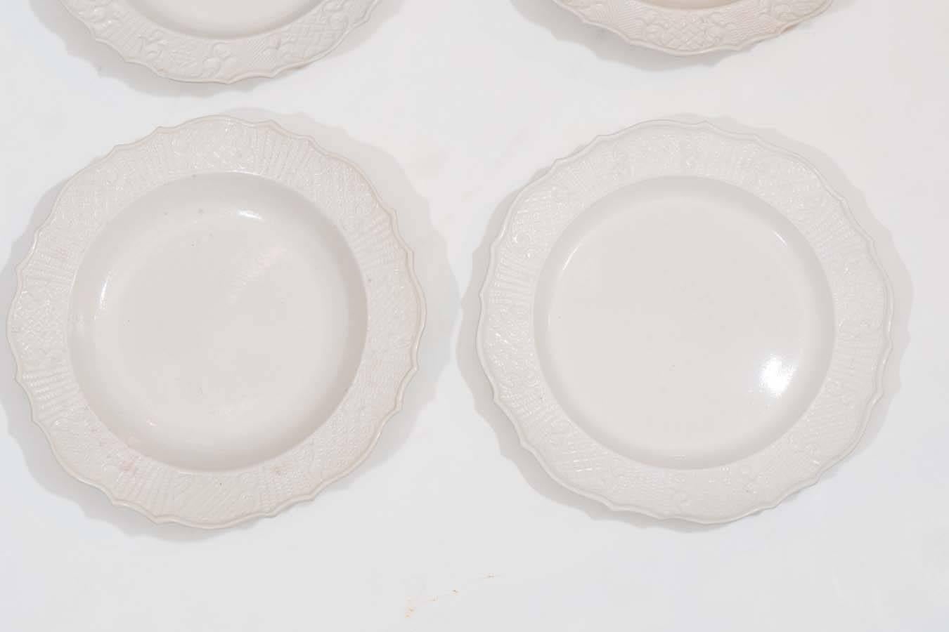 From the mid-18th century onward white body salt-glazed stoneware dinner dishes with molded borders like these were often found on the tables of colonial America. This group of dishes and deep dishes are decorated on the borders with two of the most